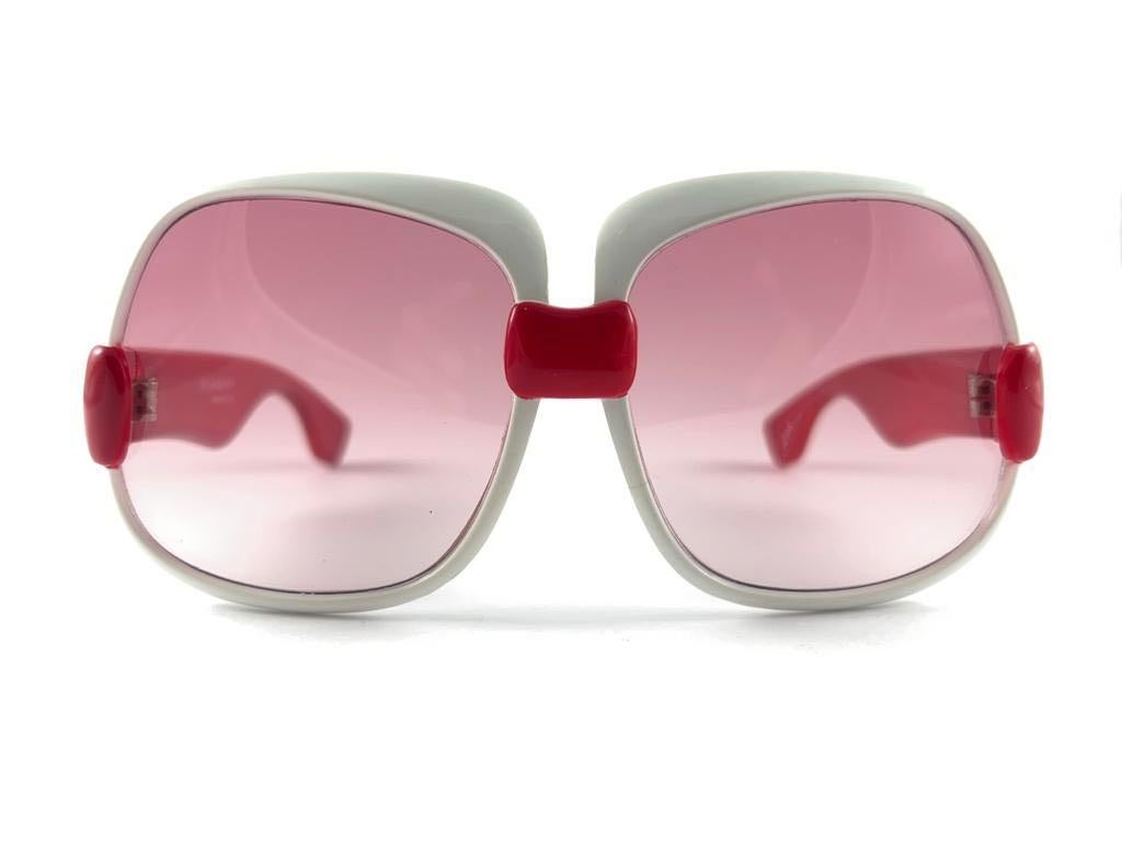 



Beautiful and stylish vintage new Yves Saint Laurent 1970’s Oversized sunglasses in a robust white & red frame. Spotless pair of candy pink lenses.
New! never worn or displayed. This pair show minor sign of wear due to storage.


This pair is an