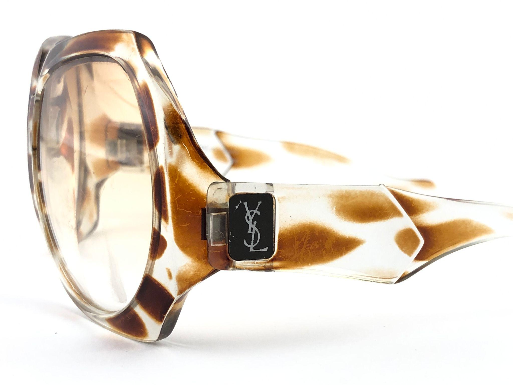 Beautiful and stylish vintage new Yves Saint Laurent 1980’s 

Oversized sunglasses with a giraffe printed accents. Spotless pair of light brown lenses. 

This pair show minor sign of wear due to storage.
Flawless pair!!!   


MEASUREMENTS

FRONT :