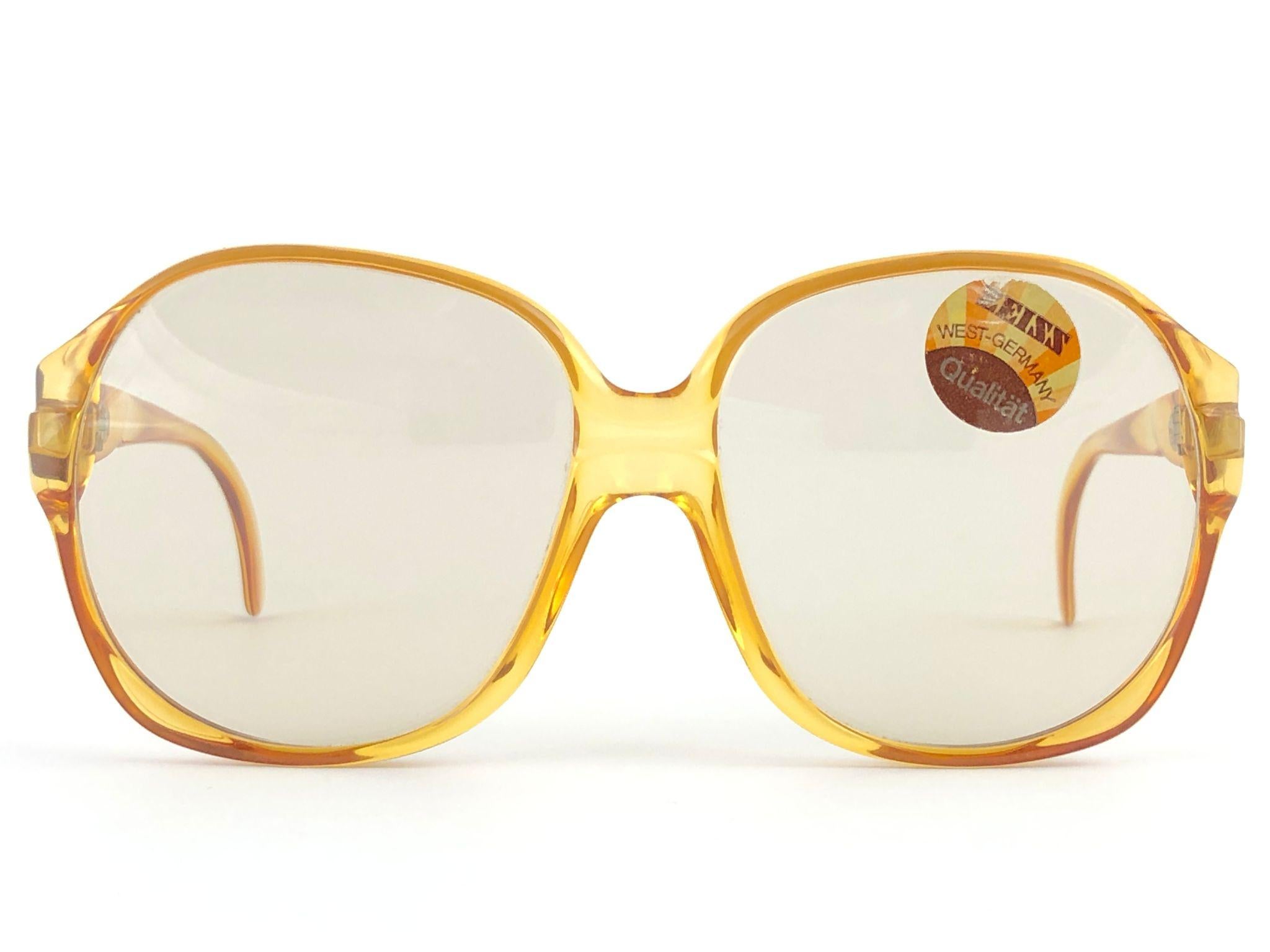 New vintage Zeiss oversized amber frame.

Two shades of clear amber frame holding a pair of light changeable lenses.

Made in West Germany


MEASUREMENTS:

Front :             14.5 cms

Lens Height :  5.8 cms

Lens Width :   5.9 cms

Temples :      