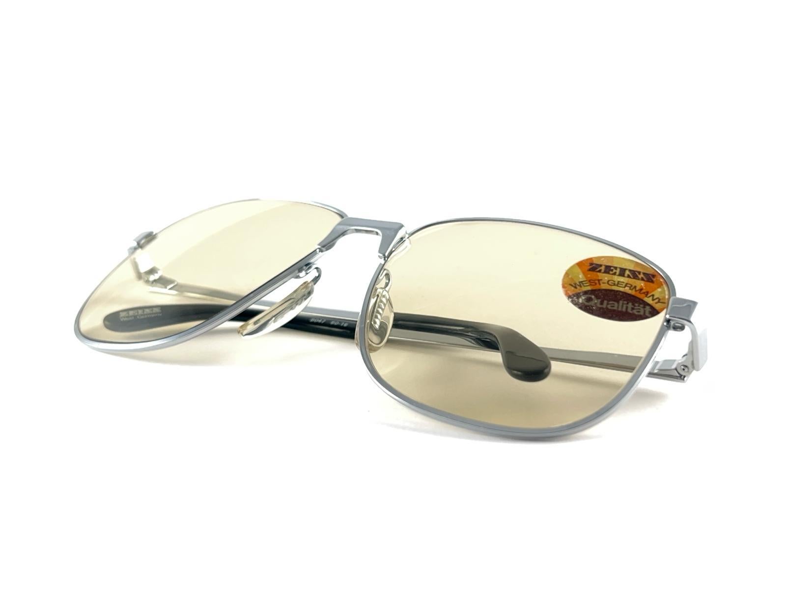 
Vintage Sonnenbrille von Zeiss 9047 Handwerkskunst und Design in einem starken und funktionellen Rahmen.
Übergroßer silberner Rahmen mit einem makellosen Paar heller Gläser.



Hergestellt in Westdeutschland


Vorderseite                           