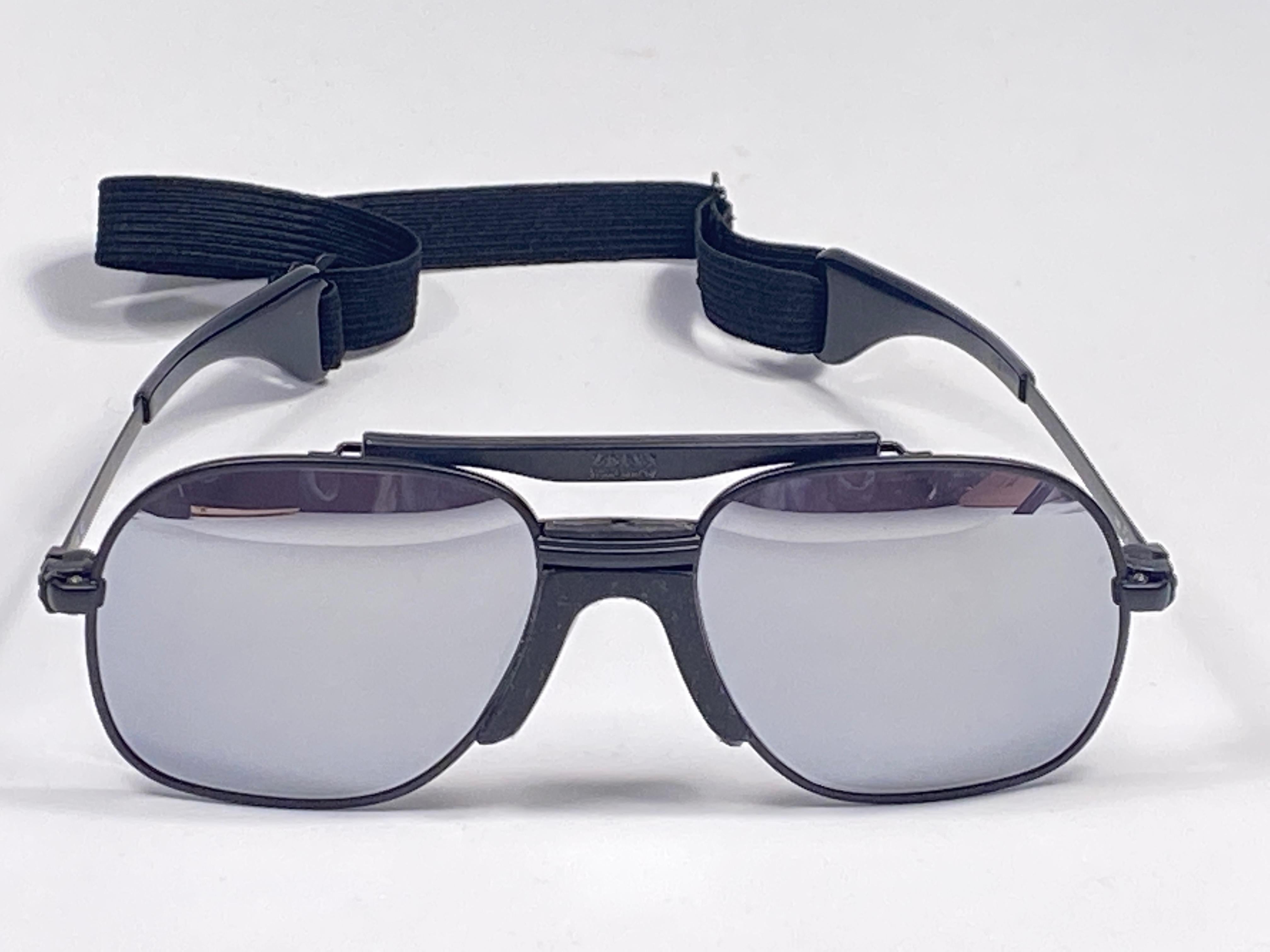 New vintage Zeiss sports oversized black matte frame with full mirror lenses and sports cord.  
Made in West Germany.

This item is new and unworn but may show minor sign of wear due to storage.

MESUREMENTS:

FRONT : 14 CMS

LENS HEIGHT : 5