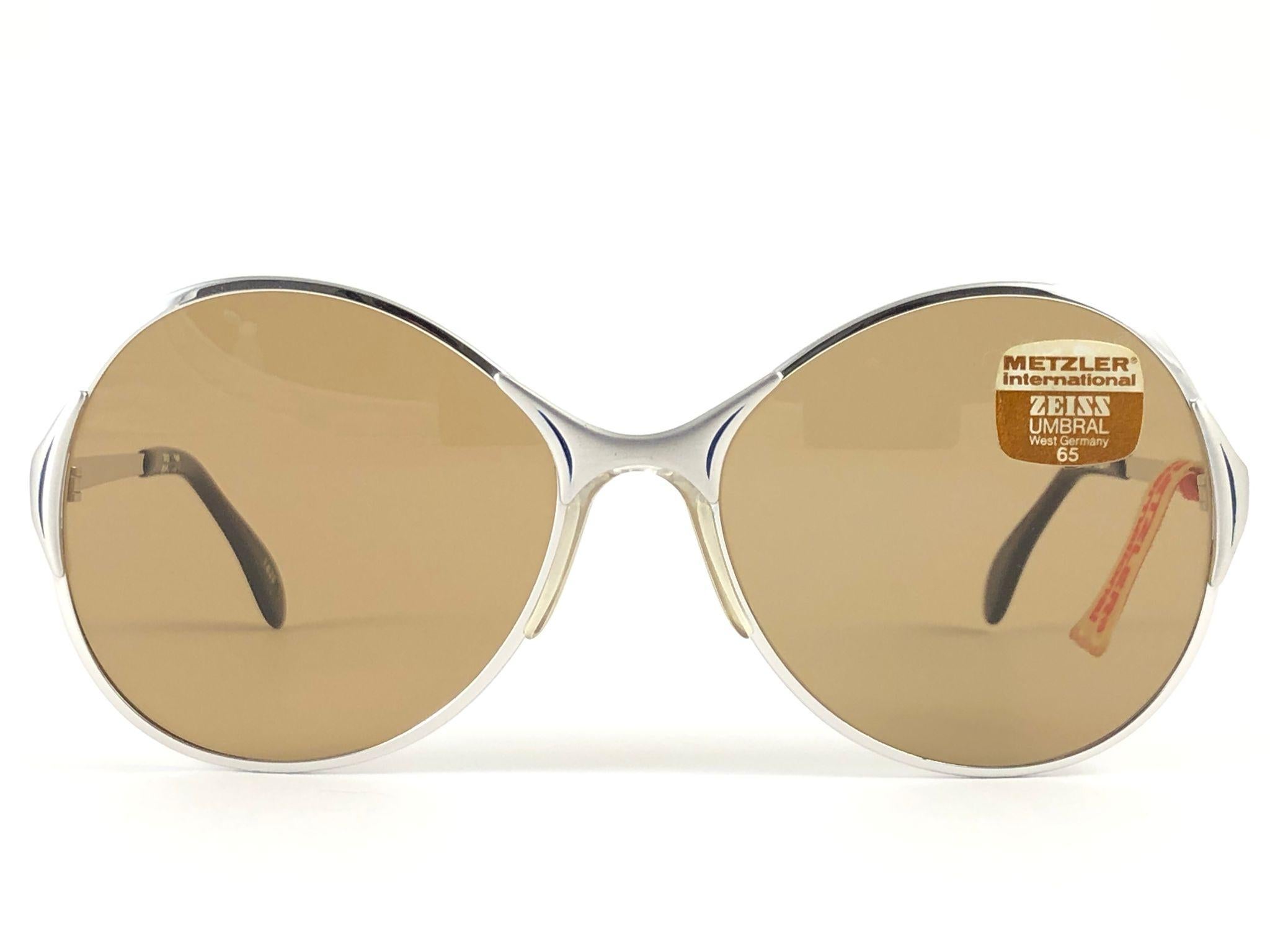 Occhiali da sole Zeiss Umbramatic Made in West Germany anni '80. 

Una montatura argentata oversize con un paio di lenti marroni di media grandezza. Telaio con lievi segni di usura dovuti alla conservazione.  

Prodotto in Germania.

MESURE:


Parte