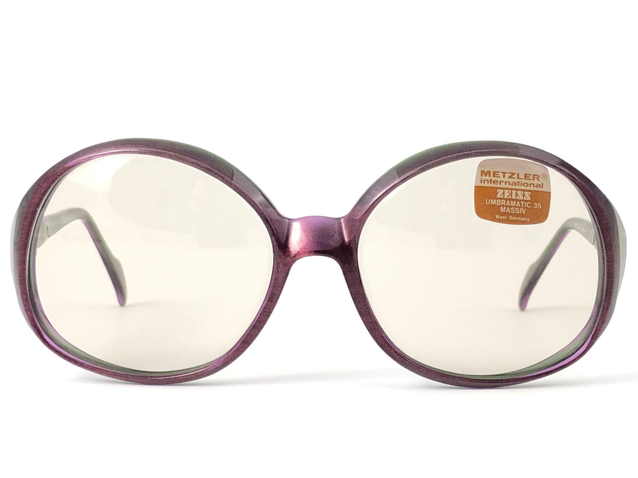Sunglasses Zeiss Umbramatic oversized purple, silver and green frame. Made in West Germany 1980's. 

Oversized translucent frame holding a spotless pair of light brown lenses. Frame with minor wear due to storage.  

MESUREMENTS:

Front : 14.8