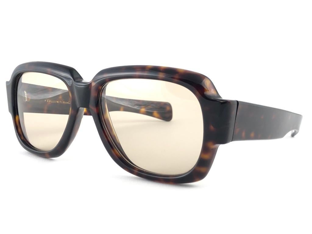 New vintage Zollitsch 217 robust oversized dark tortoise frame. Spotless light brown lenses.
This pair have slight wear on them due to to nearly 40 years of storage.  


FRONT : 15 CM
LENS  HEIGHT : 4.3 CMS
LENS WIDTH : 5.4 CMS
TEMPLES : 14 CMS

