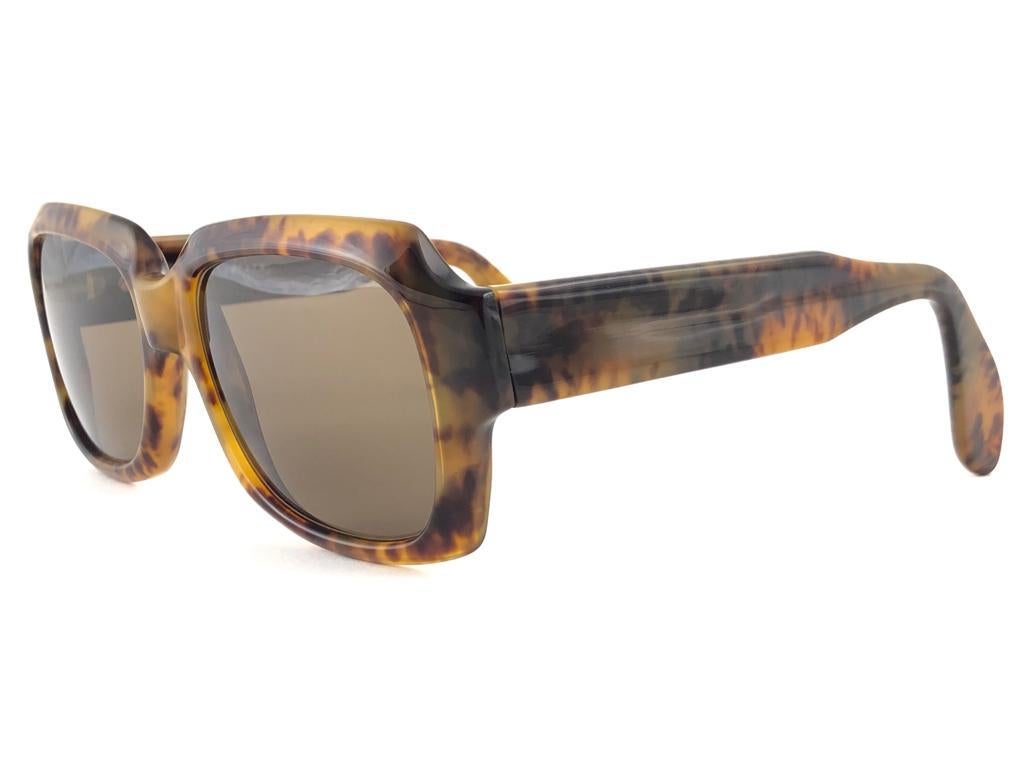 New vintage Zollitsch 249 418 tortoise robust oversized frame. Spotless solid brown lenses.
This pair have slight wear on them due to to nearly 40 years of storage.  

FRONT : 14 CM
LENS  HEIGHT : 4.4 CMS
LENS WIDTH : 5.2 CMS
TEMPLES : 14 CMS

