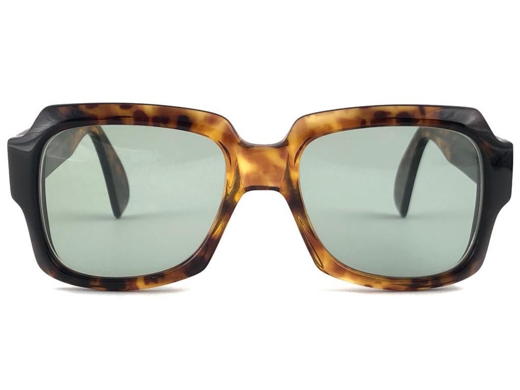 Nueva montura vintage Zollitsch 249 tortuga robusta de gran tamaño. Lentes de color verde medio impecables.
Este par está ligeramente desgastado debido a casi 40 años de almacenamiento.  

FRONTAL : 14 CM
LENTE  ALTURA : 4.2 CMS
ANCHURA DE LA LENTE