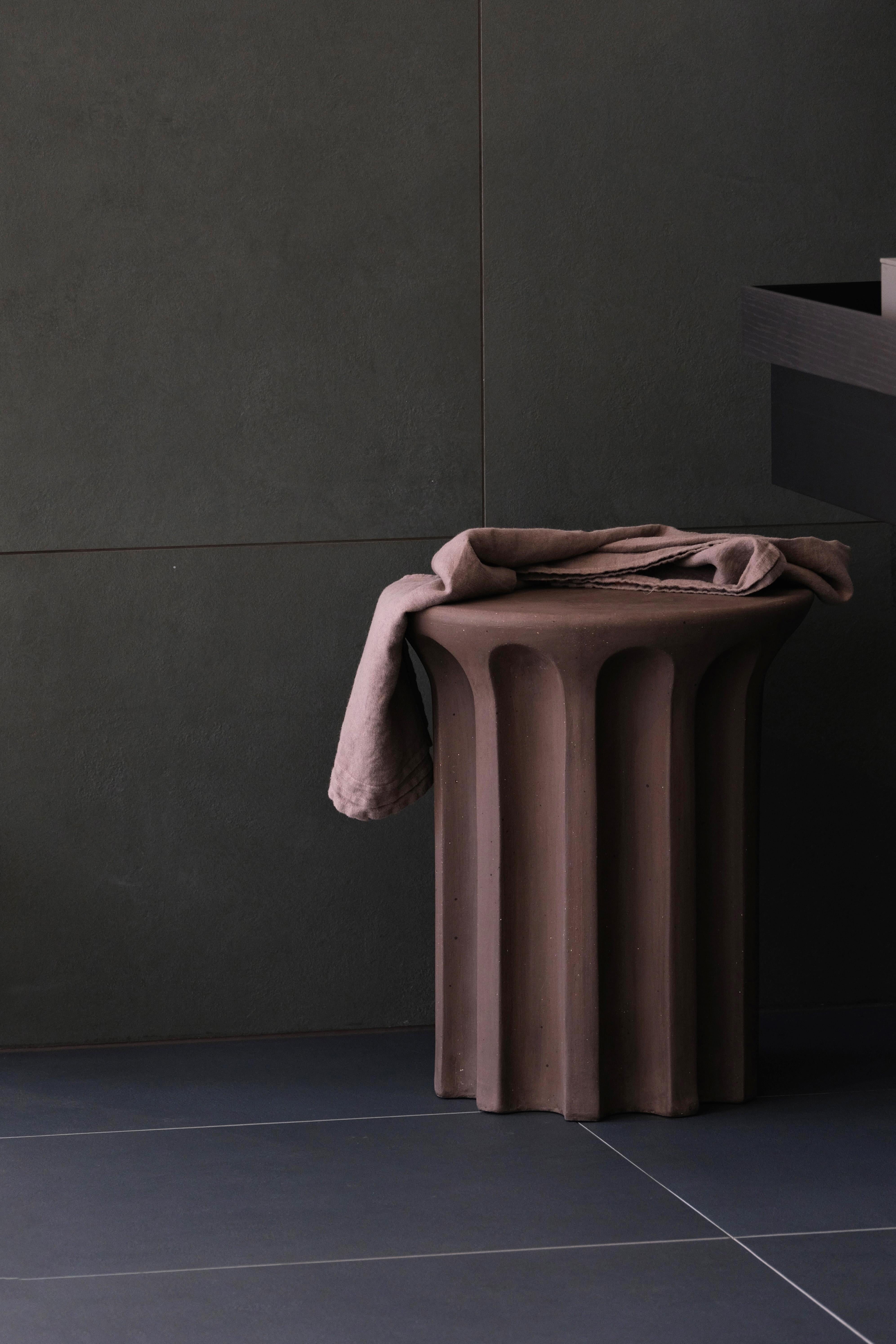 A robust terracotta side table featuring a revolving carousel of voids that call to mind the shapes used in architecture and design for centuries. A contemporary exploration of classical form that celebrates the history and legacy of this natural