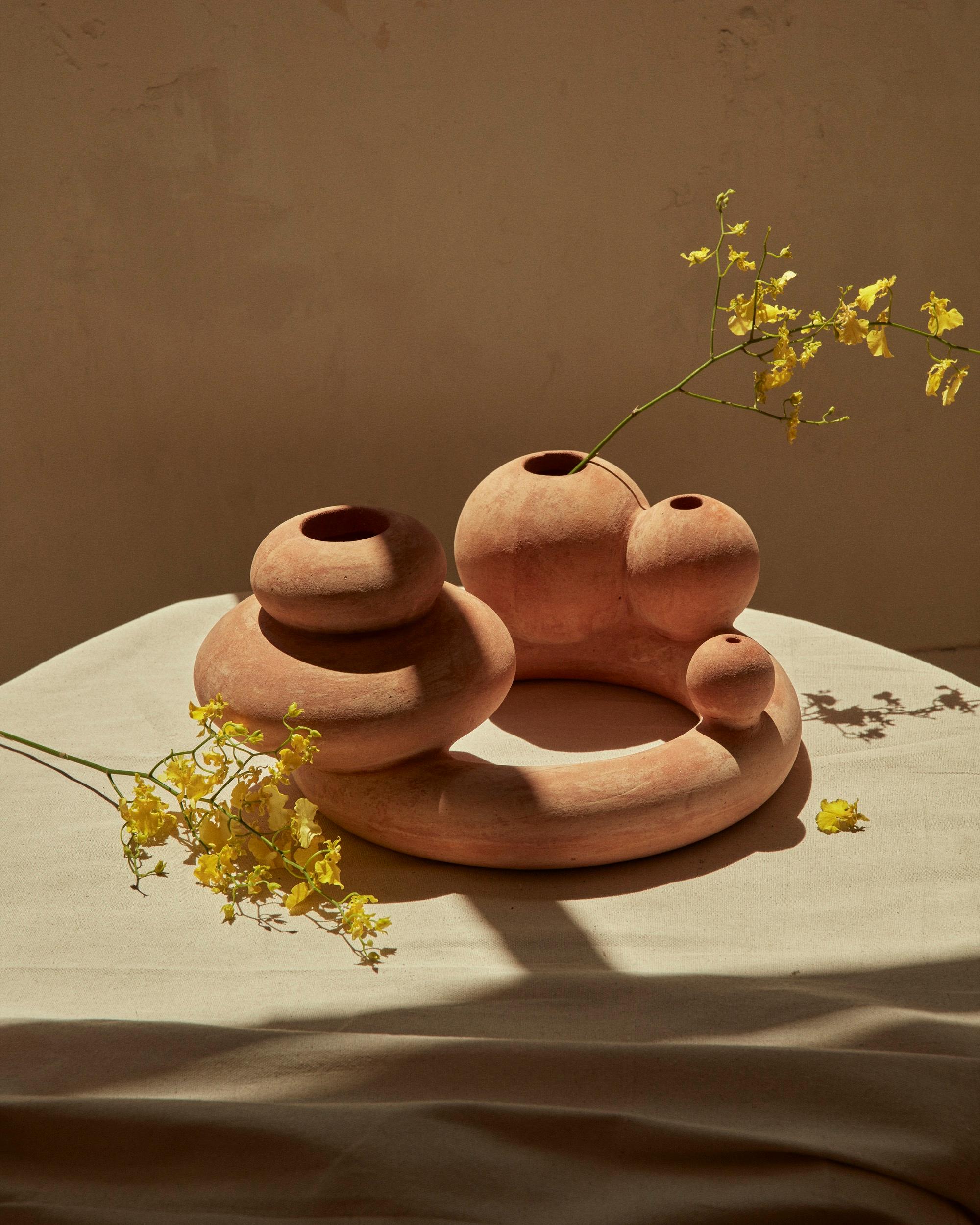 Sol ist eine geschwungene Terrakottaform, die von der manchmal seltsamen und wunderbaren Form von Blumen inspiriert ist. Sie wurde für einen praktischen Zweck als Vase und Räucherstäbchenhalter entworfen, kann aber auch als skulpturales Stück für