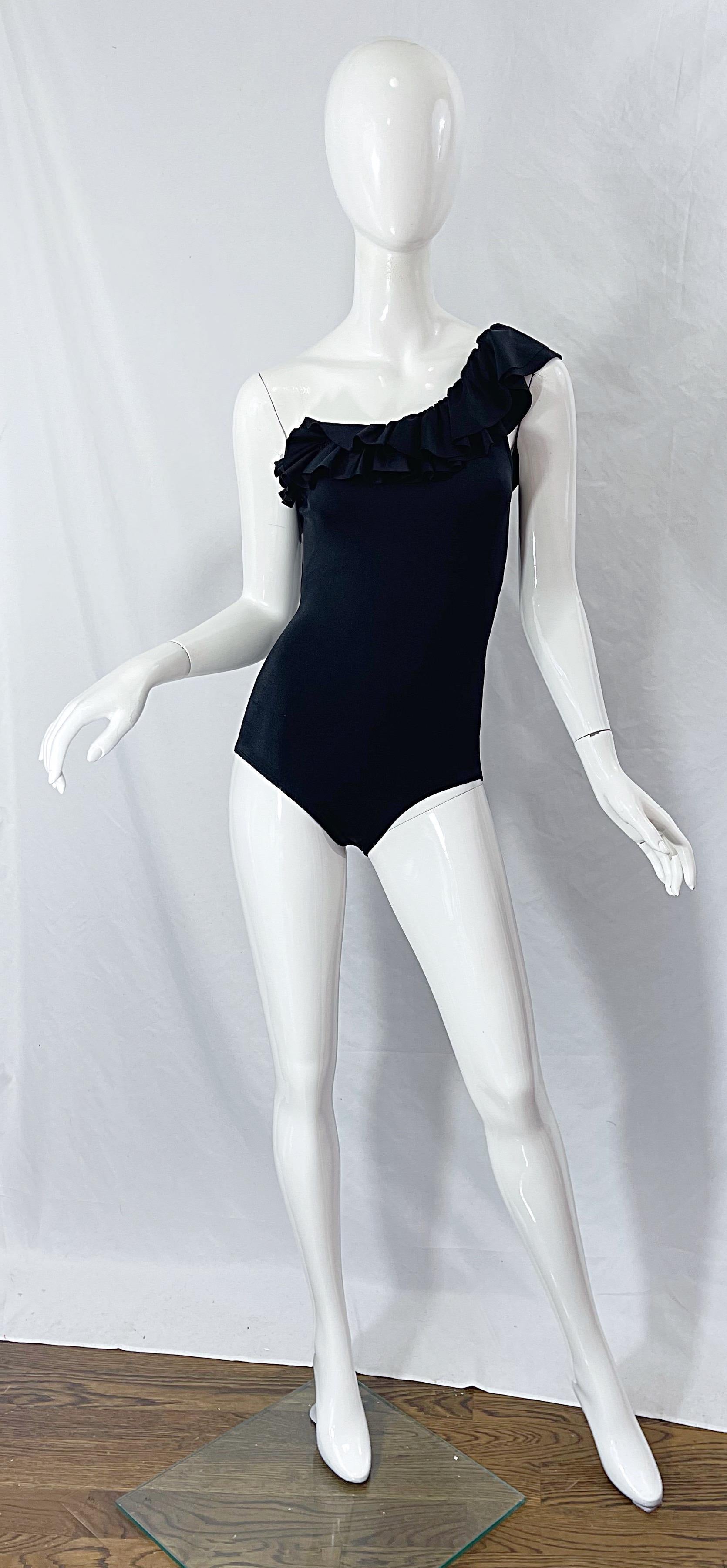 Flattering and chic deadstock ( never worn with original tags ) late 1980s vintage BILL BLASS one shoulder one piece swimsuit or bodysuit ! Features a flamenco style neckline with three layers of ruffles along the bust. Simply slips on and stretches