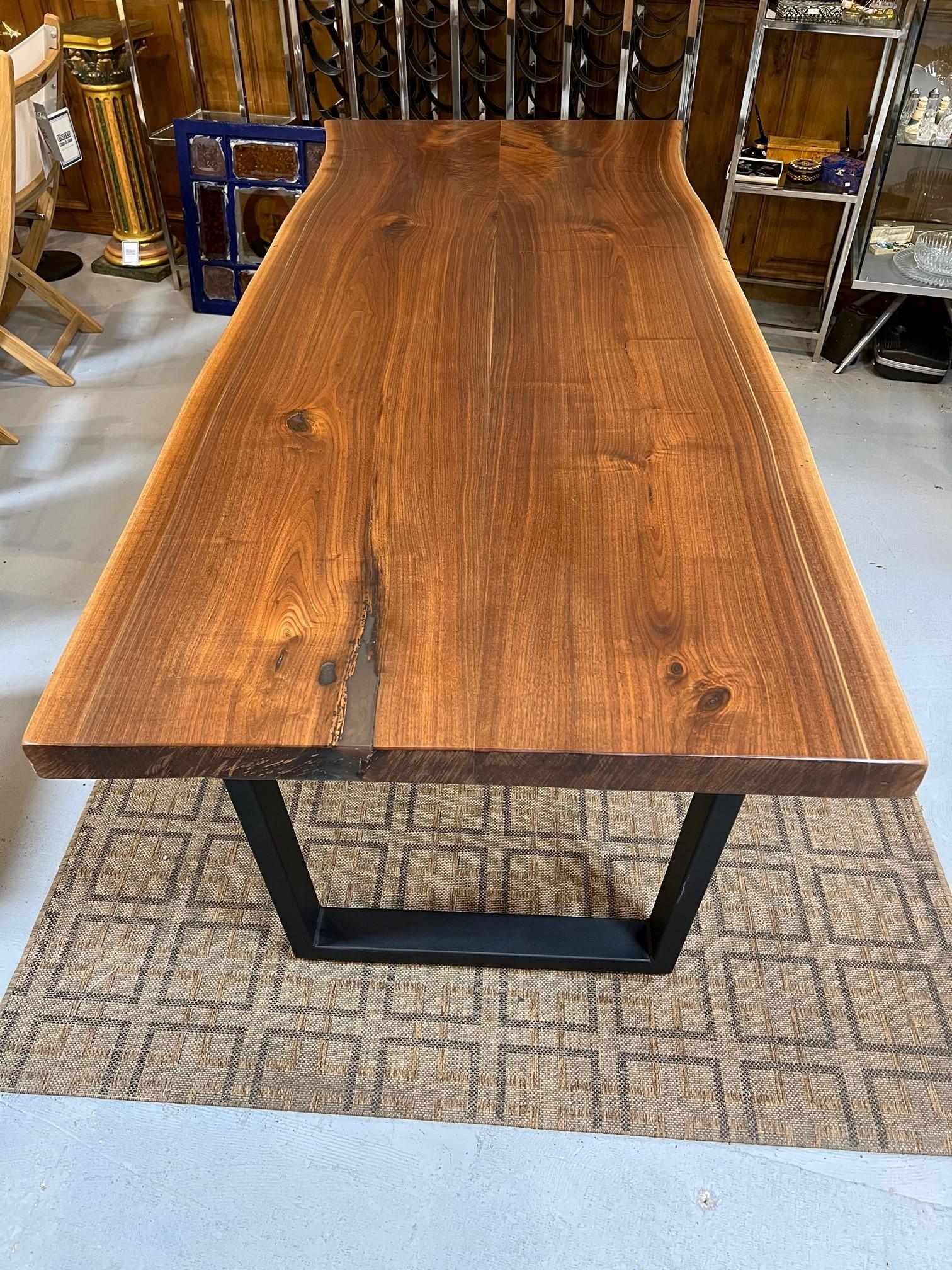 A new Walnut live edge dining table with a metal base made by the Amish in Lancaster PA. Live edge or living edge refers to the incorporation of the natural profile of the tree into at least one side of the table. This table is made from two pieces