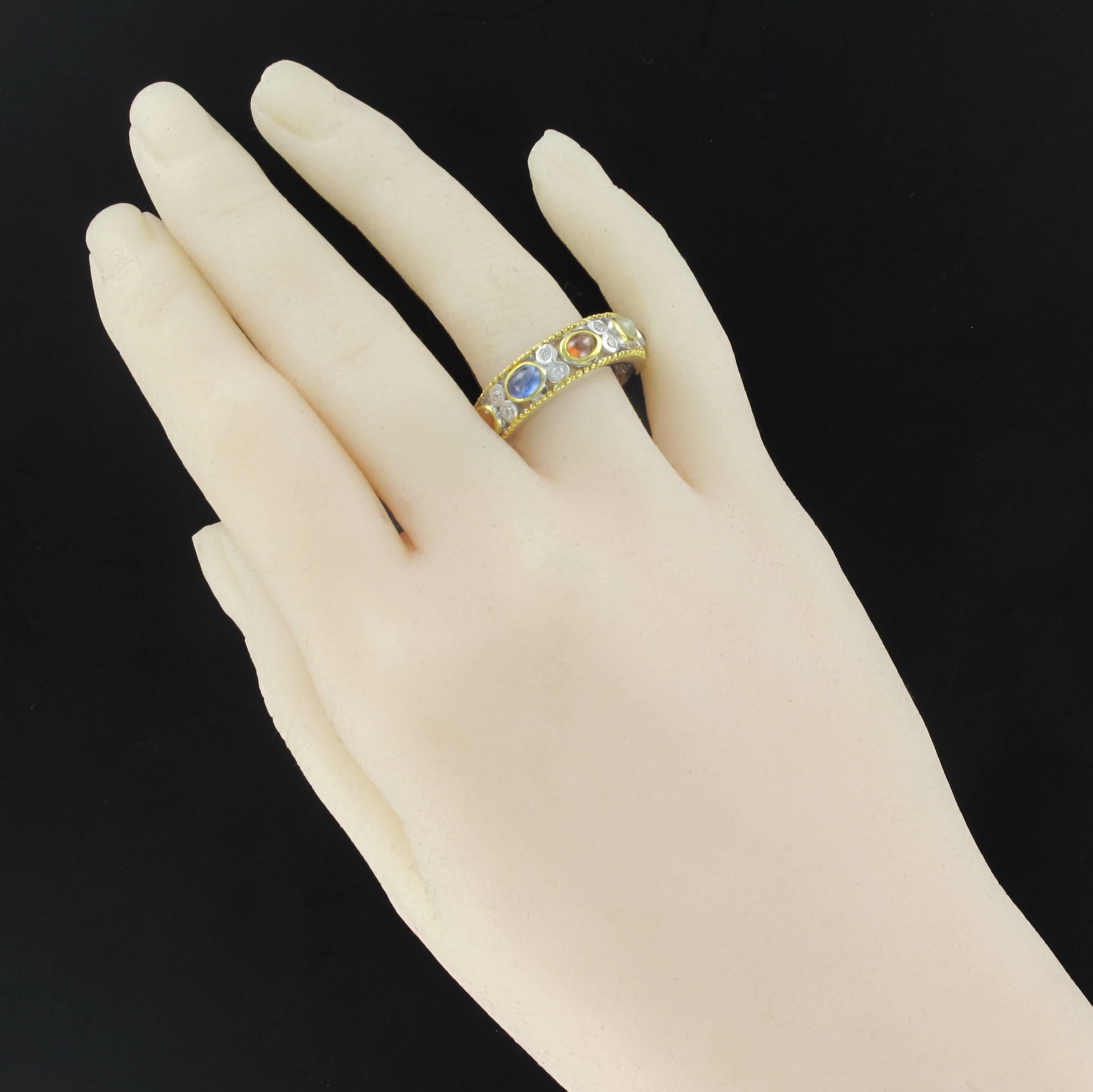 Silver ring, 925.
This band ring is closed set on its top of an alternation of white and brown zircons, sapphire, ruby and agate, closed set. The border of the ring is beaded and rhodium-plated yellow gold.
Gemstone weight: 4.90 carats