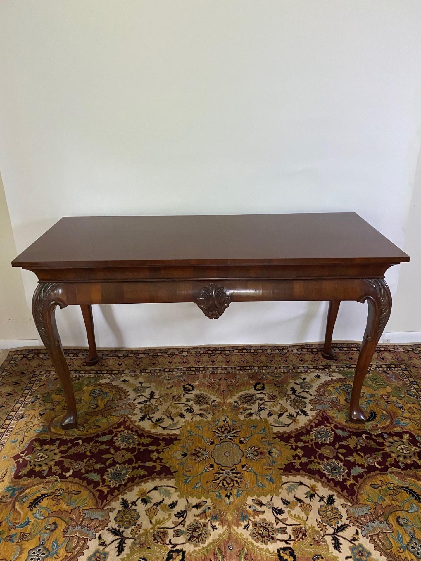 This English bench-made early Georgian style Walnut Side Table is a remarkable piece of furniture that embodies the elegance and charm of the Georgian era. Crafted with meticulous attention to detail, this side table showcases the timeless beauty of