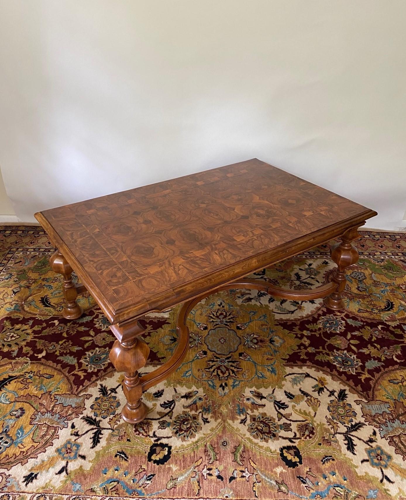 This New William & Mary style English bench-made Walnut rectangular coffee table is a stunning piece of furniture that exudes elegance and craftsmanship. It features a combination of exquisite materials and intricate design elements.

The table's