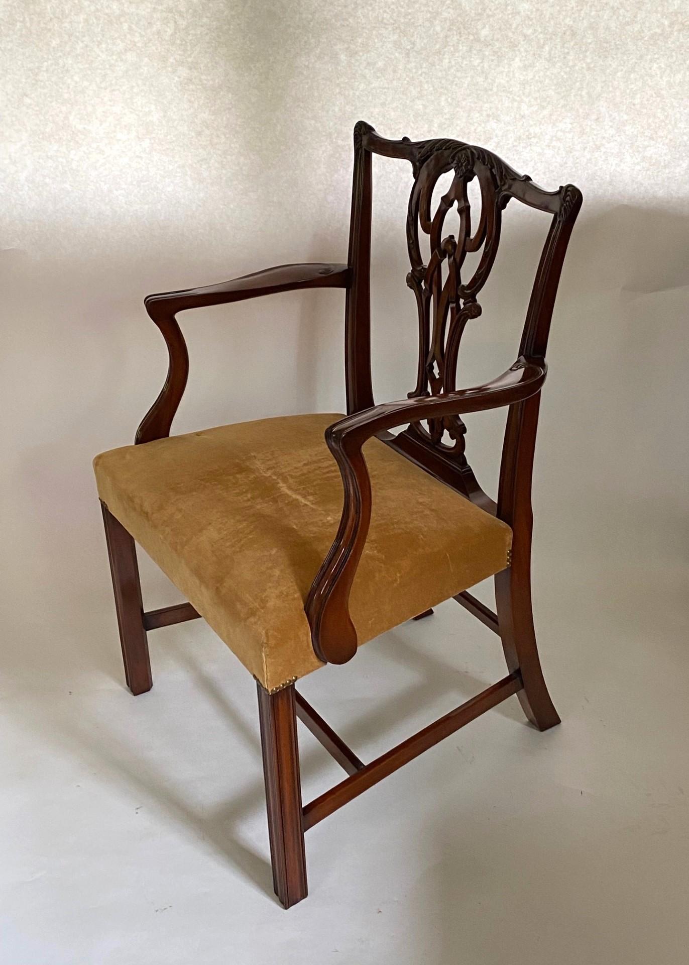 Una bella poltrona in stile Chippendale in mogano di Wood &New Hogan. Realizzata in Inghilterra, questa elegante sedia è caratterizzata da un motivo fogliare riccamente intagliato a mano lungo la ringhiera superiore a serpentina, sopra una stecca