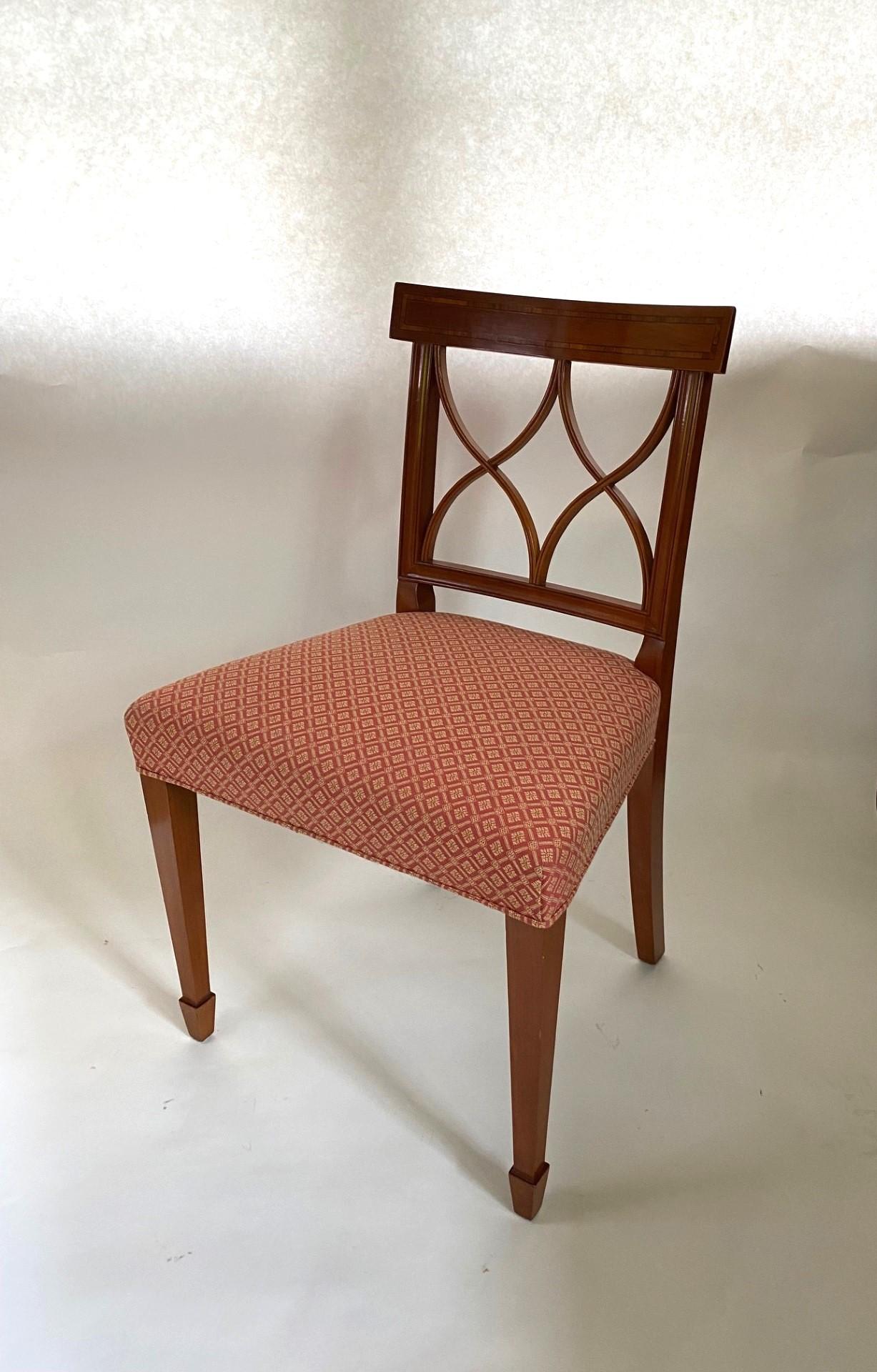 Questa poltrona in stile Sheraton di Wood & Hogan, finemente lavorata, è realizzata in Inghilterra con legni selezionati di frutta e presenta un pannello posteriore intarsiato in legno di tulipano sopra un elegante design a doppia X. La sedia poggia