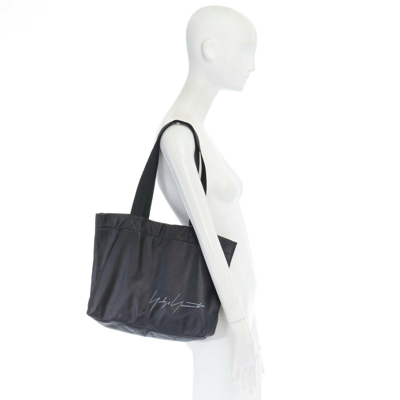 new YOHJI YAMAMOTO black leather white signature woven strap shoulder tote bag
YOHJI YAMAMOTO
Black genuine leather tote. 
White signature printed at front face. 
Tonal stitching. 
Black woven shoulder dual top flat handle straps. 
Fully lined in