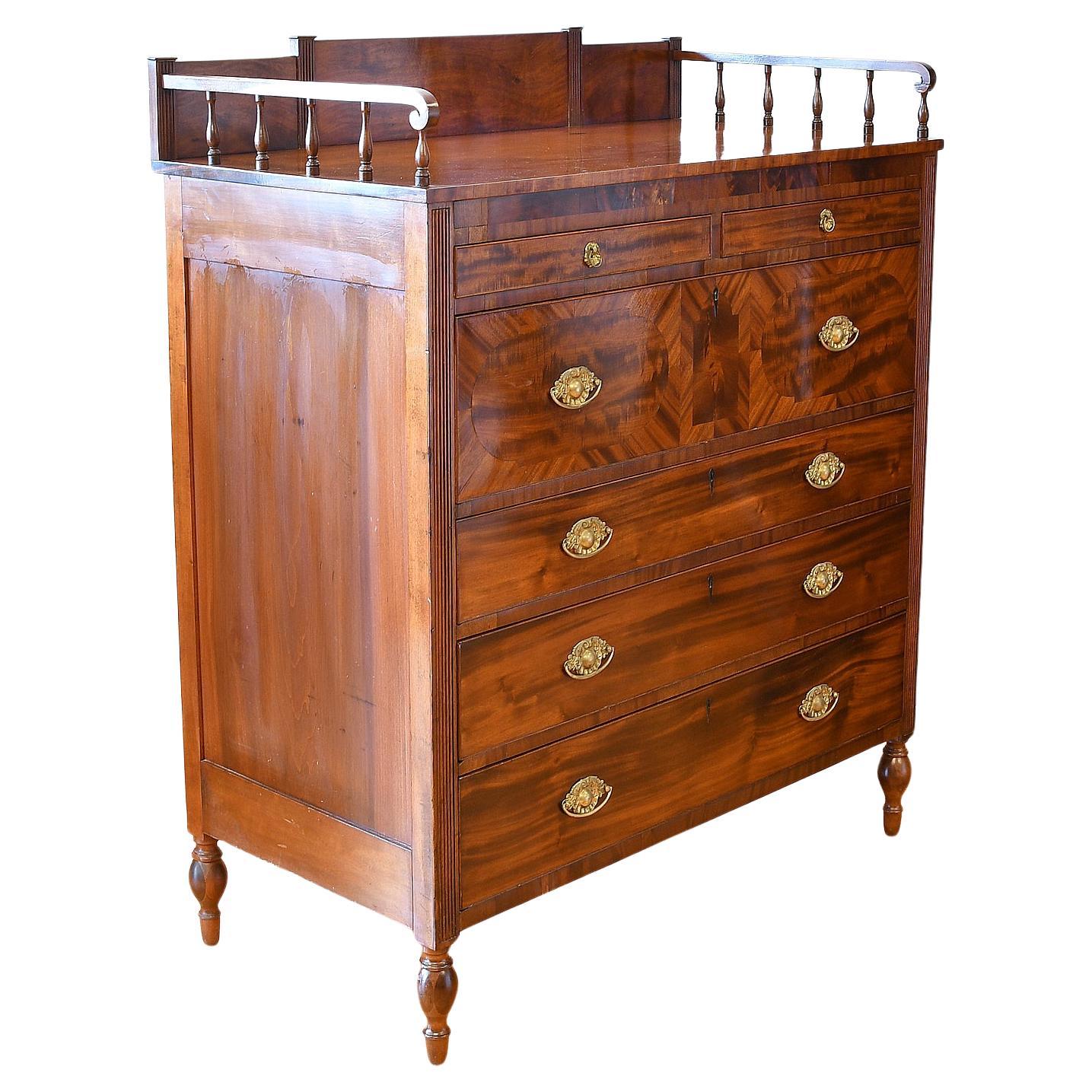 A lovely American Sheraton chest of drawers in mahogany from New York,  circa 1815. Veneer work on second drawer is reminiscent of the work of Michael Allison. Chest features an original gallery in solid mahogany with two small drawers over four