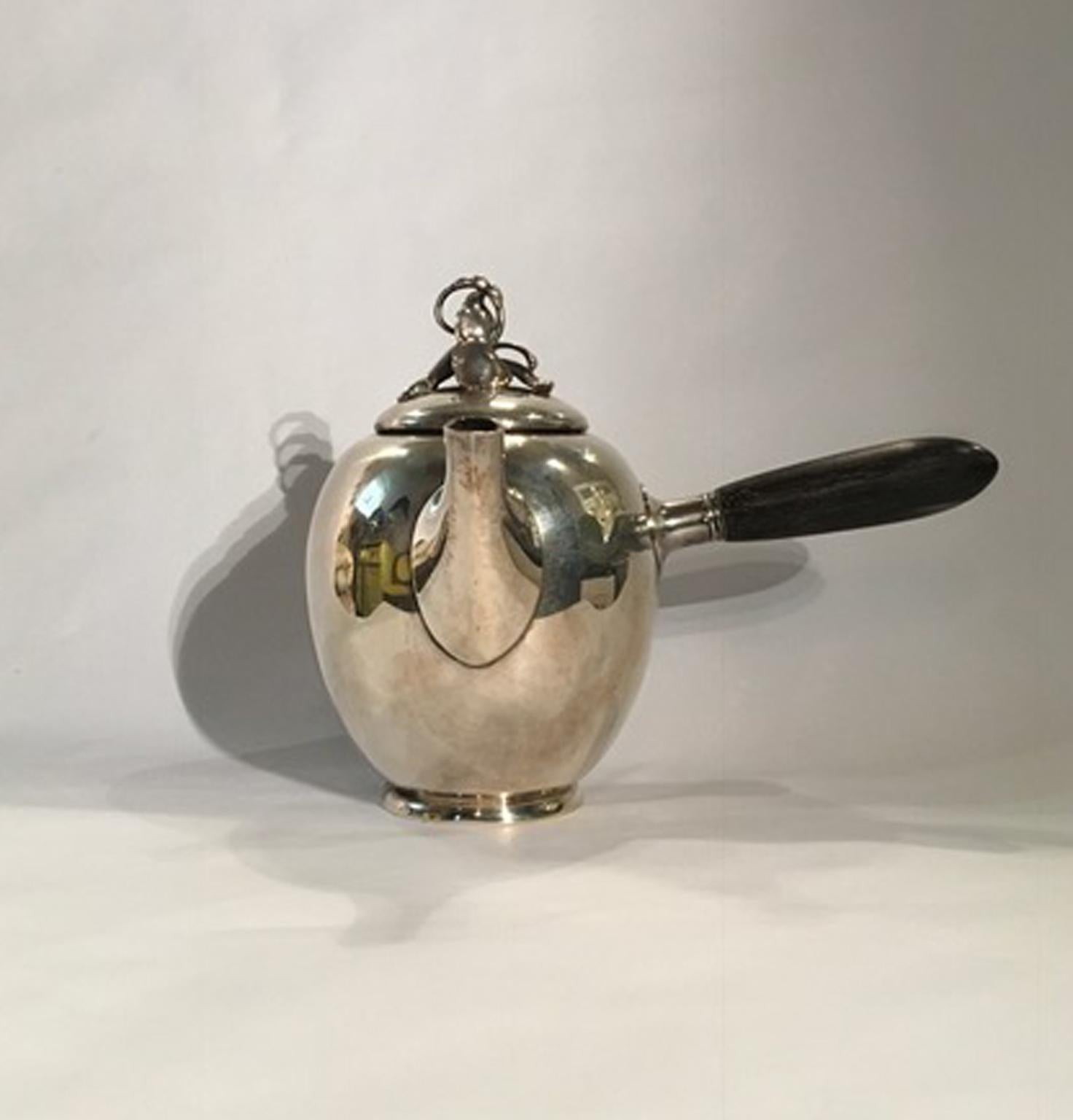 New York by Gorham early 20th century chocolate pot in sterling silver 

This piece of timeless beauty is made in silver sterling, with an ebonized wooden handle. A delicate bellflower is the handle on the cover. A piece to collect.
Fully