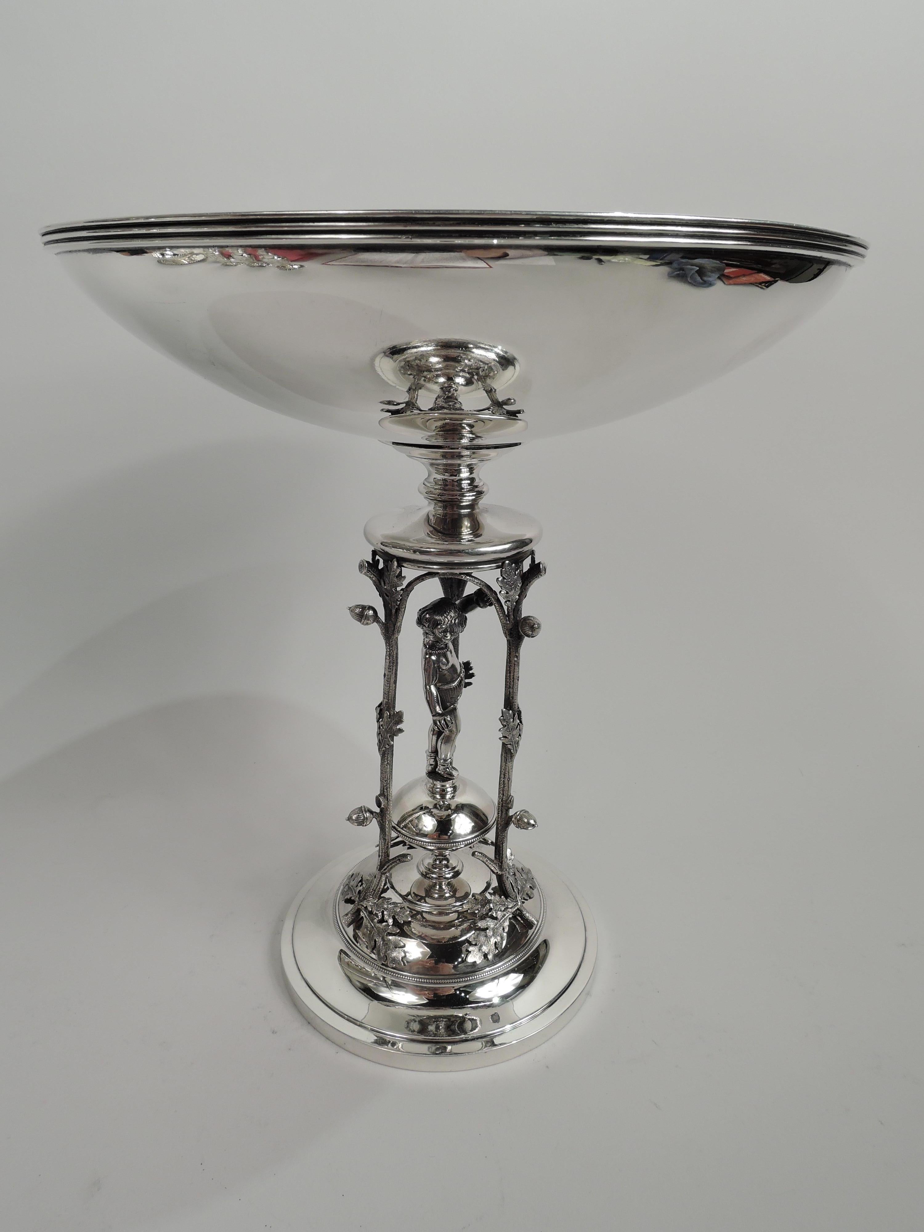 Classical sterling silver compote. Made by John Wendt for Ball, Black in New York, ca 1870. Round and curved bowl mounted to open support comprising three leafing oak shoots with acorns inset with cast figure of standing boy holding a ball in each