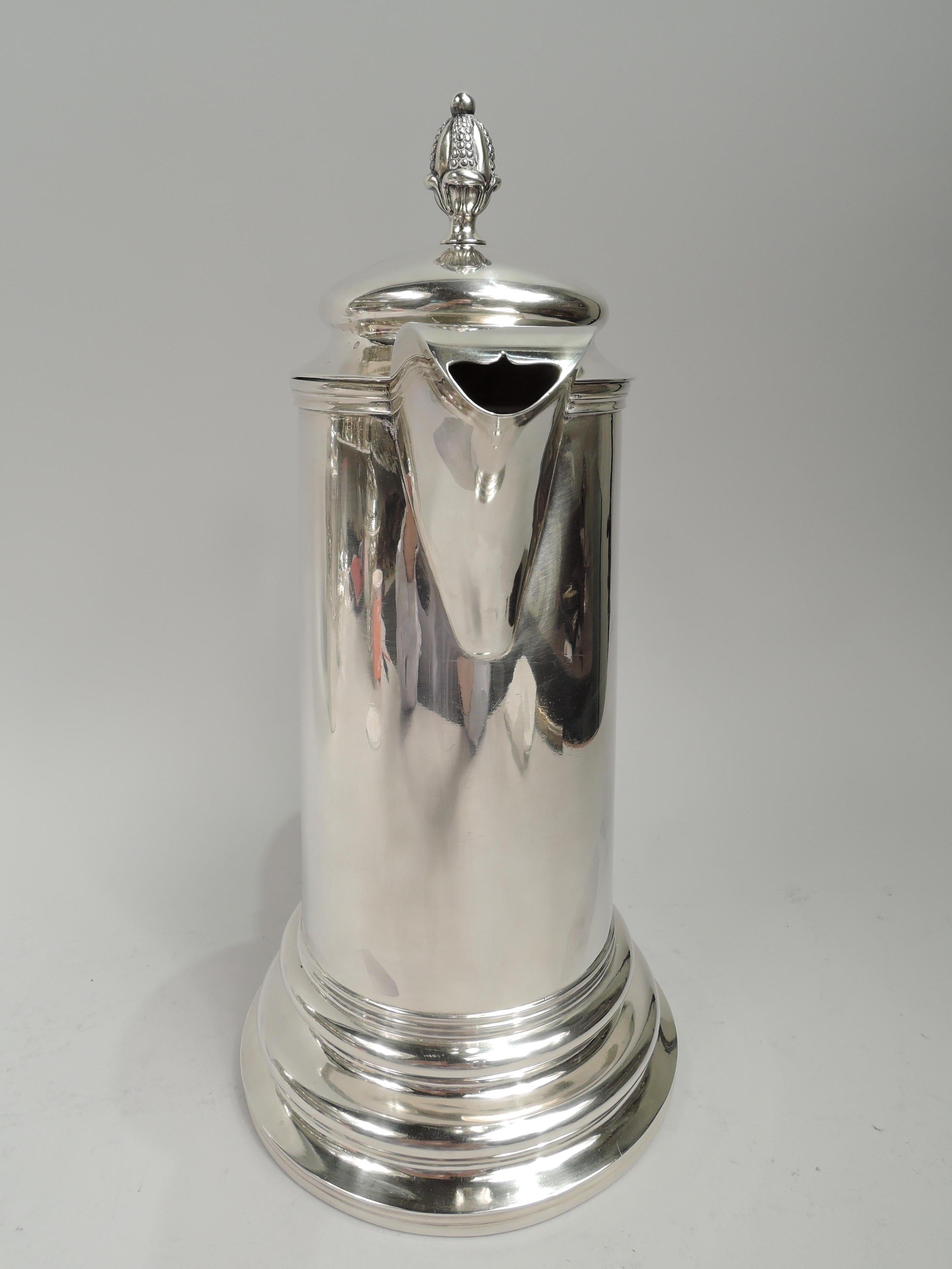 Federal classical coin silver flagon. Made by Nicholas James Bogert in New York, ca 1820. Upward tapering cylinder on spread and stepped base. S-scroll handle with ribbed thumb rest and heart terminal. Hinged and domed cover with bud finial. Curved