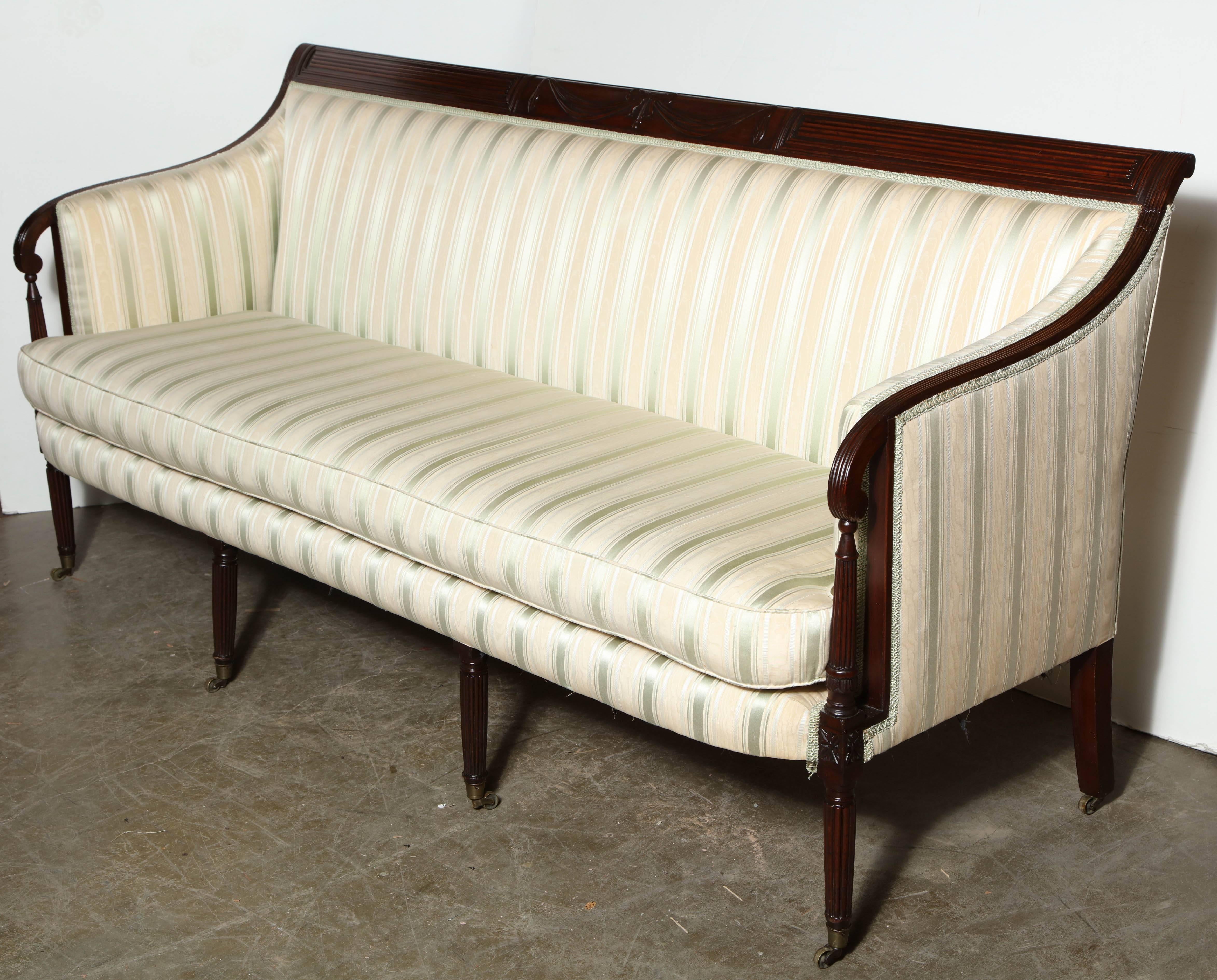 An America, New York, Federal sofa with bowknot and drapery carving, reeded legs with casters.
Attributed to Duncan Phyfe.