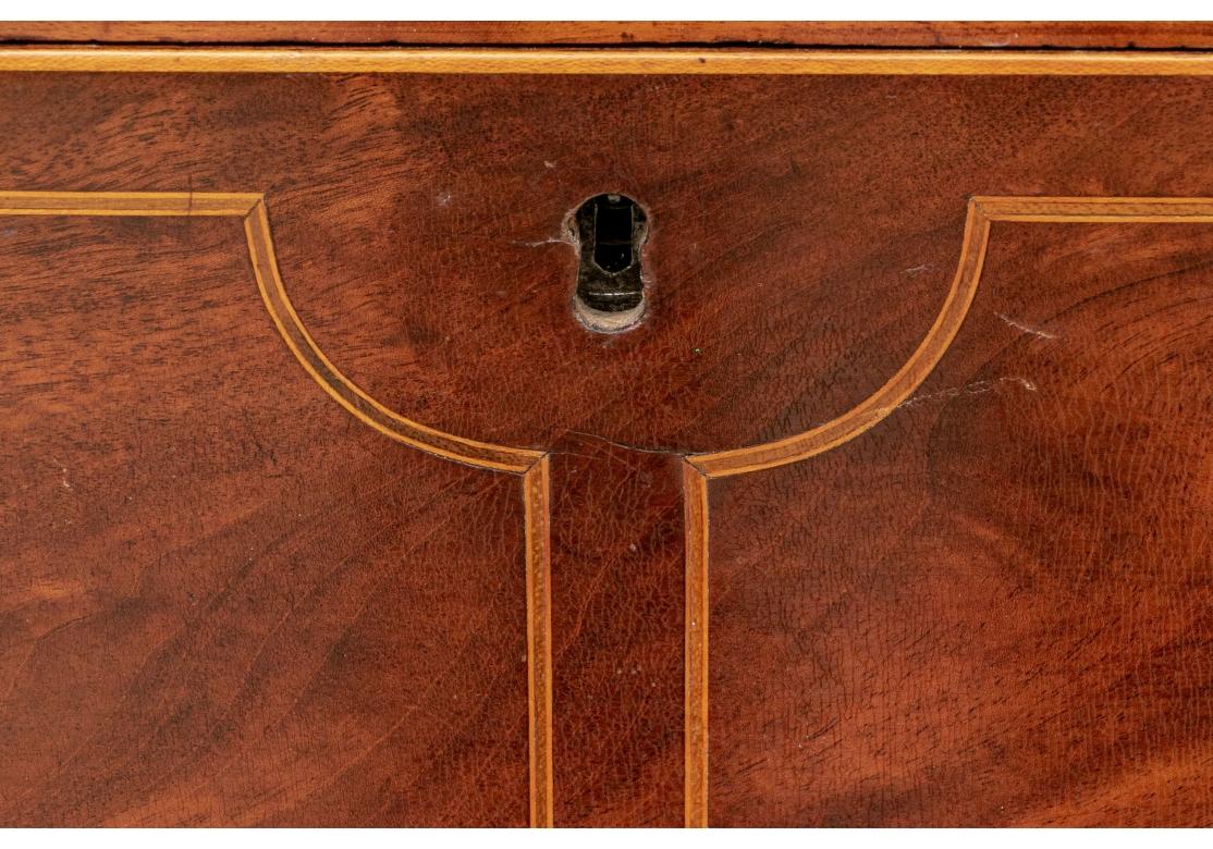 A New York flame mahogany federal butler's desk with drop down (side snap operation) door revealing a green leatherette tooled work surface. The interior with a center door concealing storage and an inside drawer that is flanked by two 