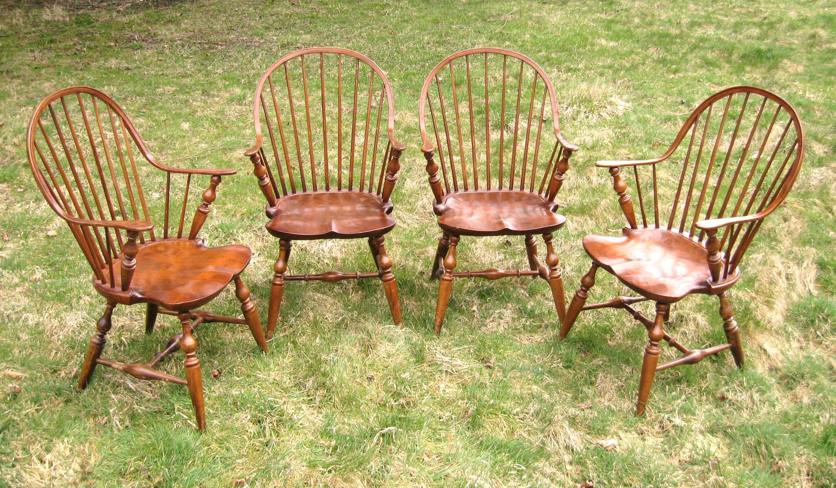 Here is a set of 4 Windsor style handcrafted continuous armchairs by B. Delin. The chair's design is a Classic Windsor shape consisting of a spindle back with, and a steam-bent arched crest continuing into the chair's arms. The seat is a shield