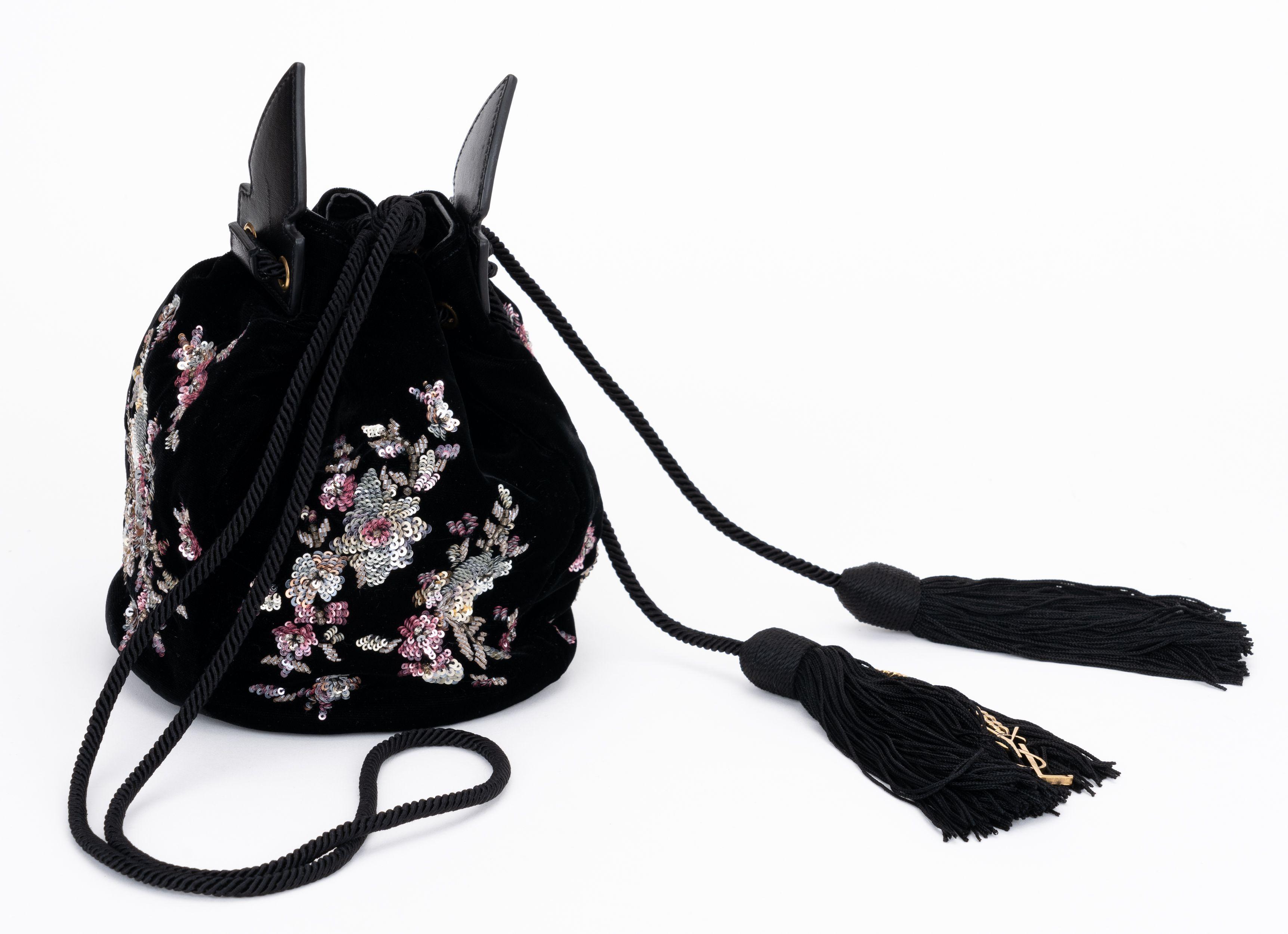 YSL new in unused condition black velvet bucket bag. Embroidered exterior and black leather lining interior. Silk tassels with antique gold chains and logo. 
Shoulder drop 21