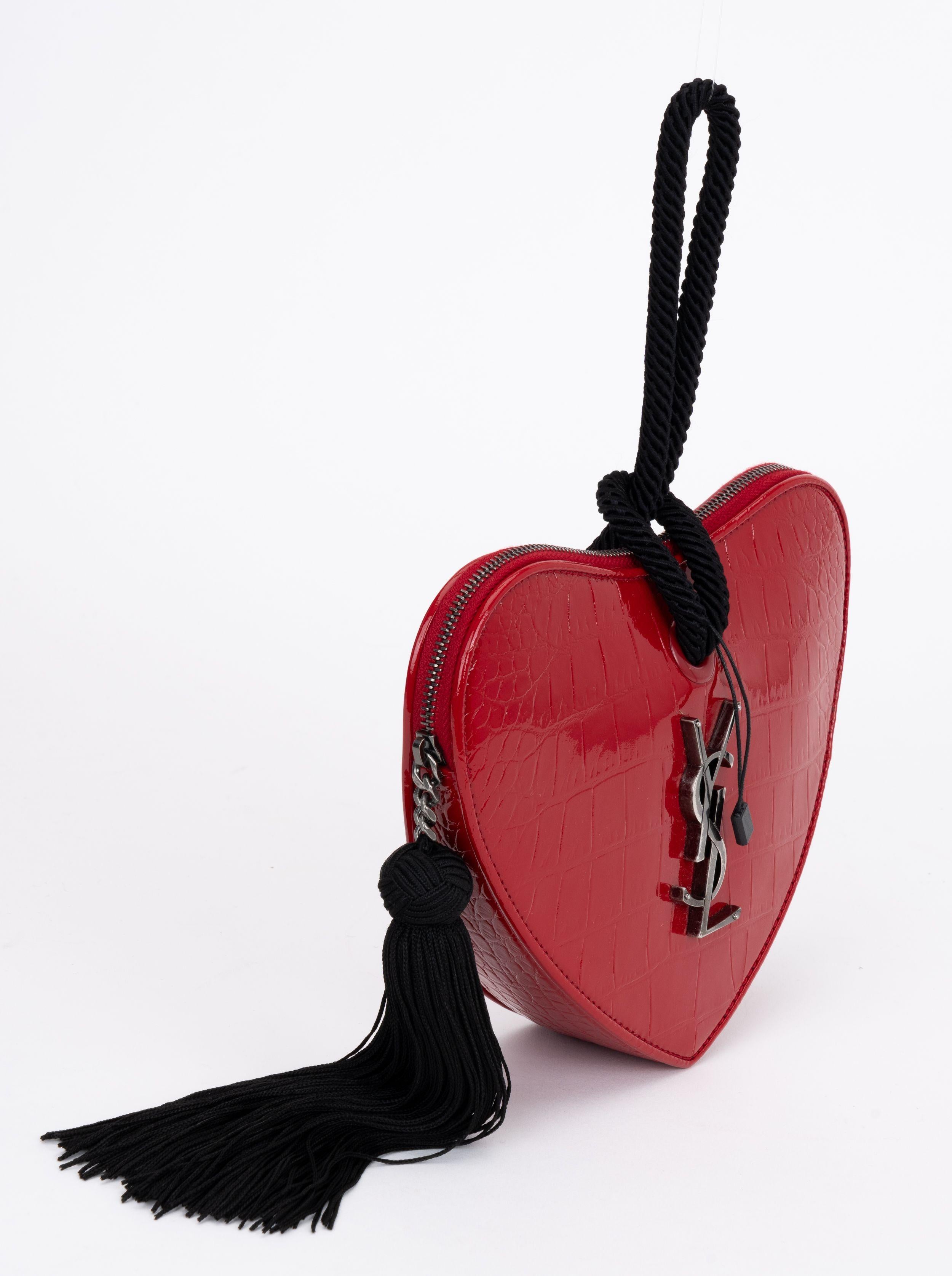 YSL new red patent embossed croc leather heart shaped clutch with black handle and silk tassel. Front silver YSL logo. Bag can fit a cell phone inside. Comes with booklet and original dust cover.