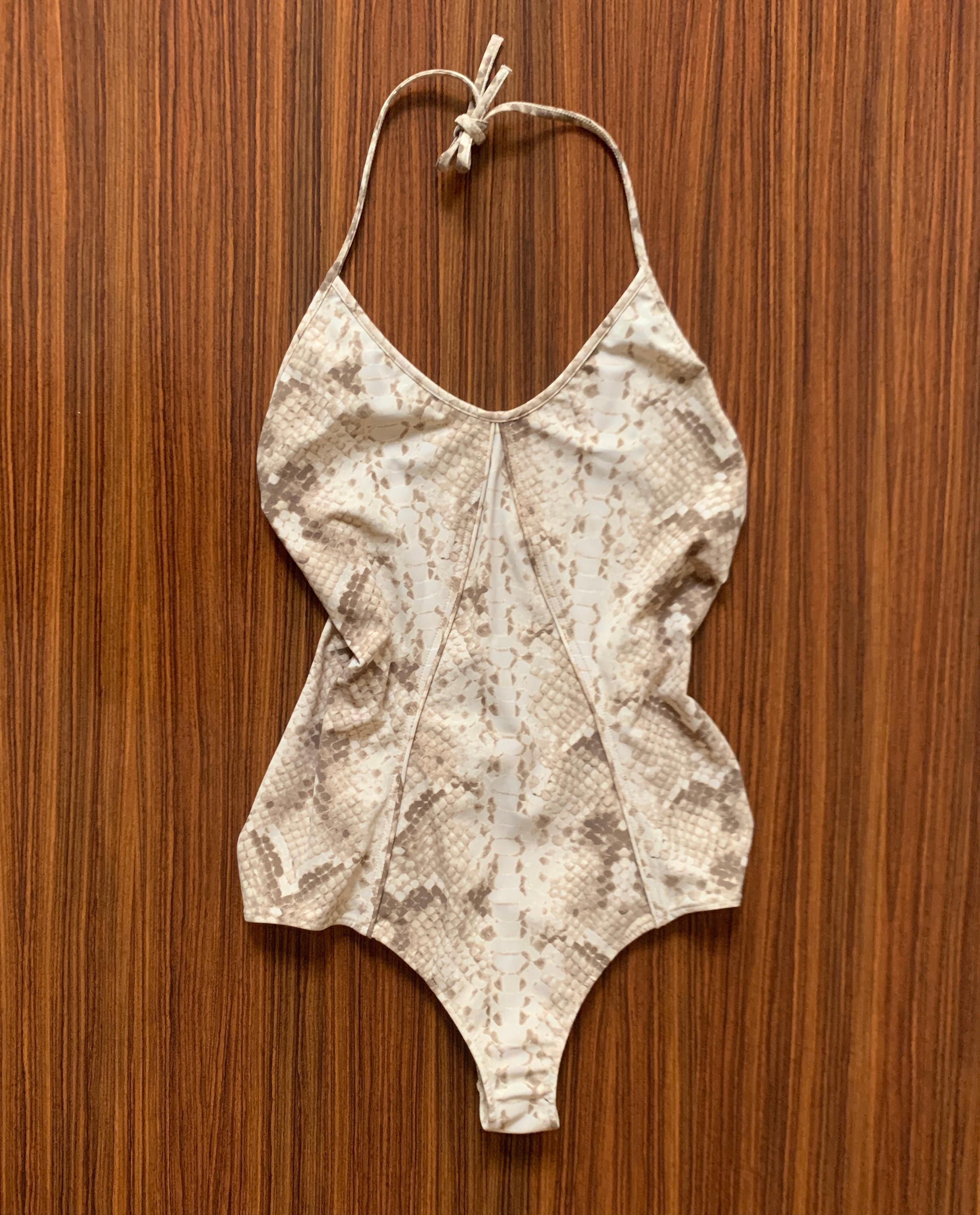 Yves Saint Laurent tan and grey reptile print backless swimsuit with halter top. Seam detail at front. Tie closure. 

80% nylon, 20% elastane.
Lined in nylon.

Made in Italy.

Size FR 40, approximate US 8.
Lots of stretch, measurements taken