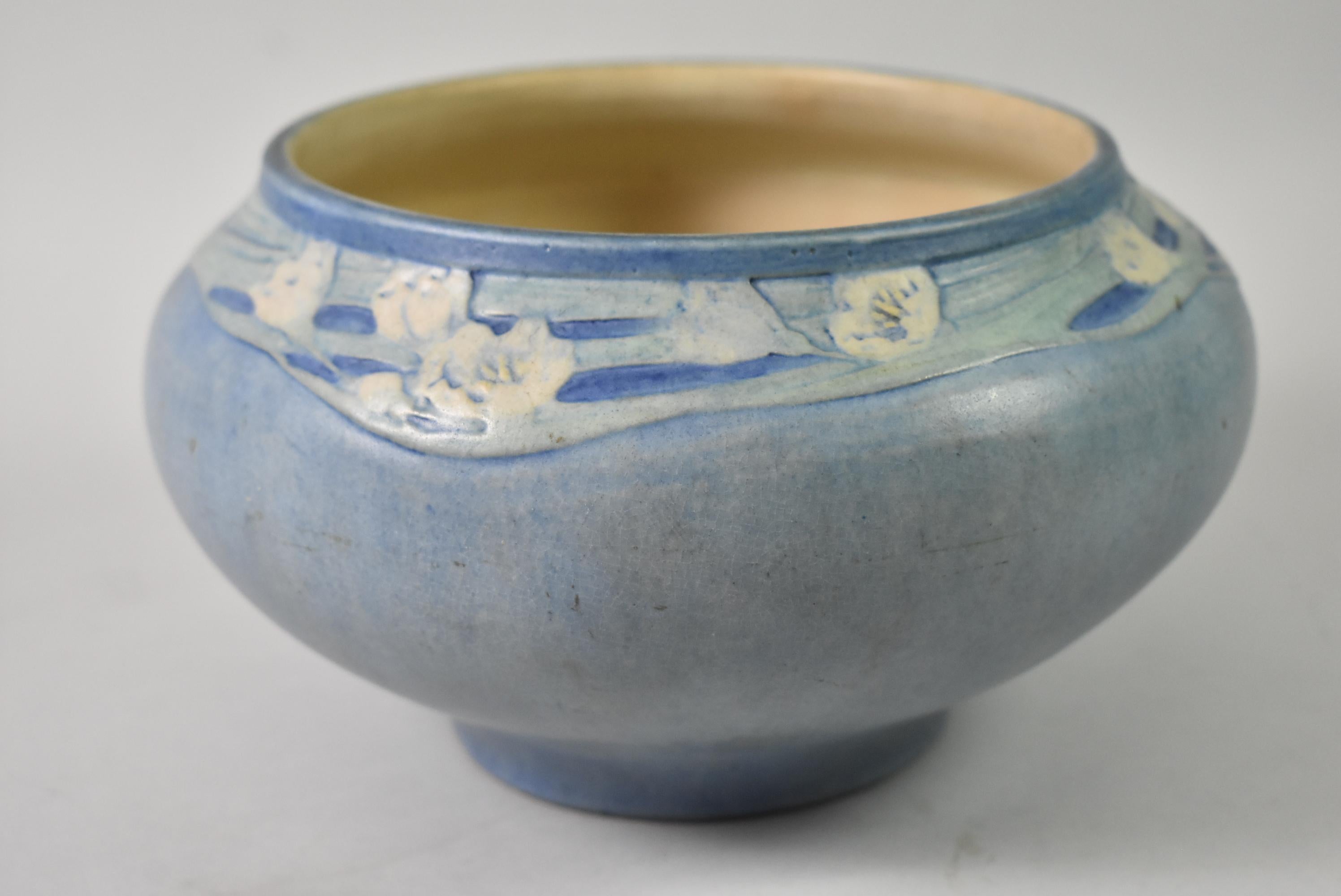 Questo vaso in ceramica artistica del Newcome College dell'inizio del XX secolo è stato decorato da Anna Francis Simpson. Le ceramiche Newcome sono considerate ceramiche d'arte americane dell'inizio del XX secolo. Il vaso blu a forma di ciotola è