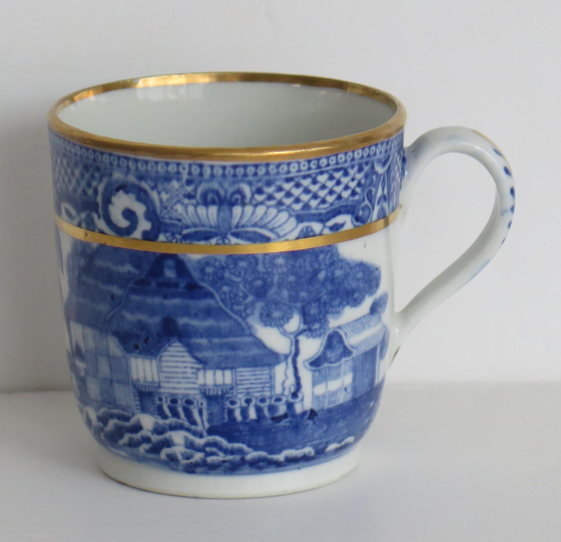 This is a porcelain blue and white, gilded Coffee Cup, attributed to New Hall, in the early 19th century George 111rd period, circa 1805-1810.

The piece is well potted on a low foot with a plain loop handle.

The cup is decorated under-glaze