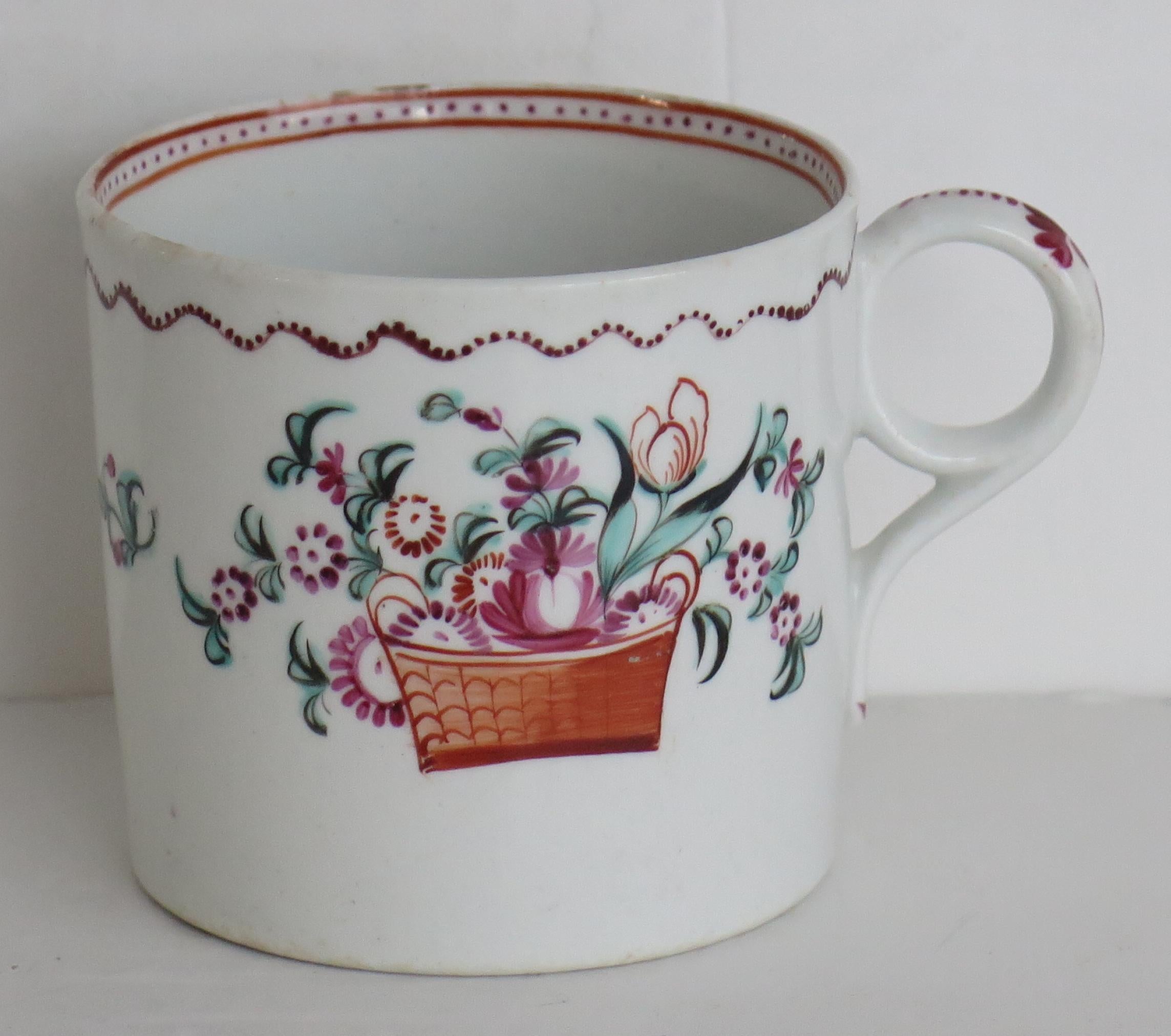 This is a hard paste porcelain coffee Can by New Hall, dating to the late 18th century, George 111rd period, circa 1790 t0 1795.

The piece is well potted on a low foot with a ring handle.

The cup is decorated over-glaze with hand painted