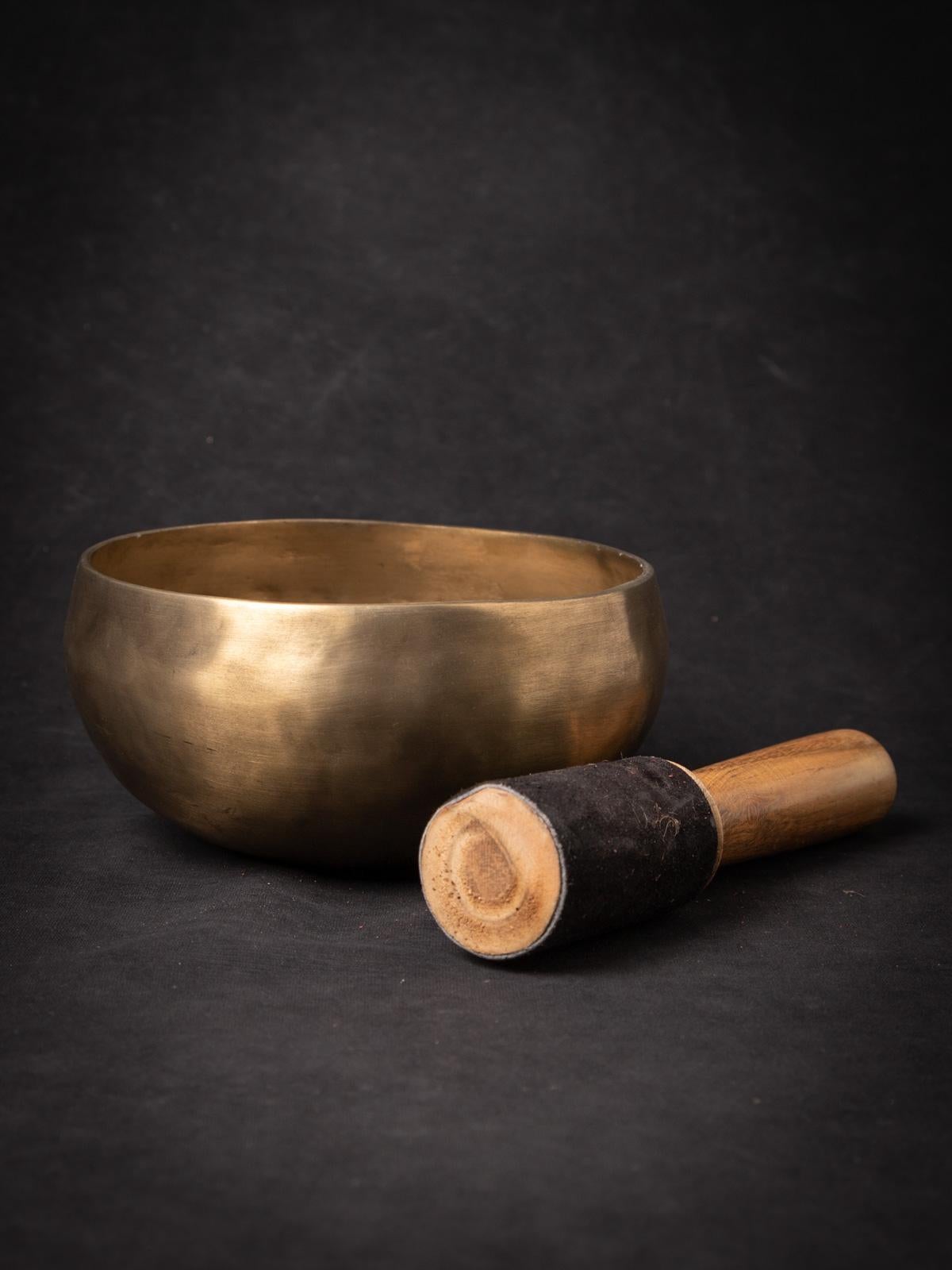 The newly made bronze Singing bowl from Nepal is a testament to the skilled craftsmanship and musical tradition of the region. Created from bronze, this singing bowl stands at a height of 8.6 cm and has a diameter of 17.8 cm. Crafted with a focus on