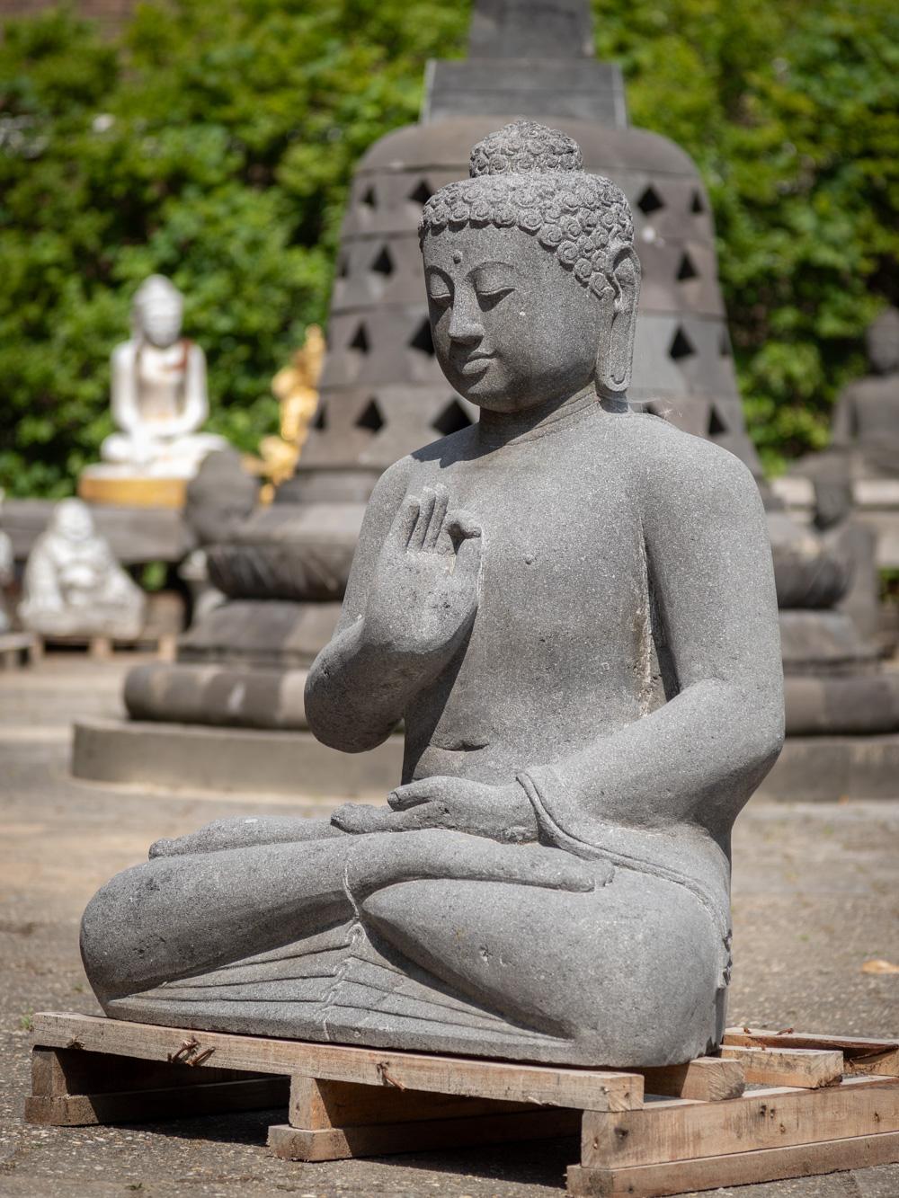 The large lavastone Buddha statue from Indonesia is a remarkable testament to artistic skill and spiritual representation. Hand-carved from a single block of lavastone, this statue stands at an impressive height of 107 cm, with dimensions of 87 cm