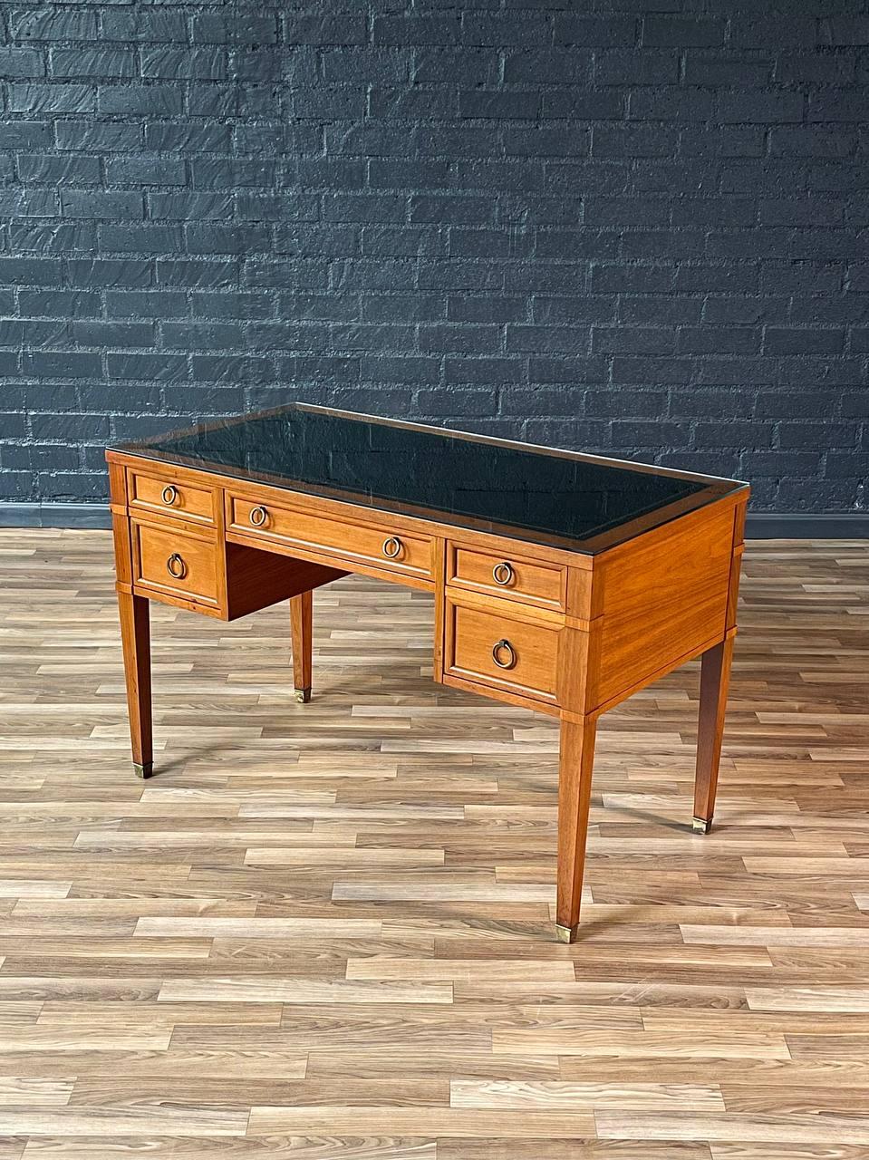 Condition: Original Vintage Condition

Designer: Milling Road Furniture / Baker  
Manufacturer: Milling Road Furniture / Baker  
Materials: Light Walnut, Original Leather Top, Patinated Brass Accents, Glass Top

This elegant Mid-Century Modern desk