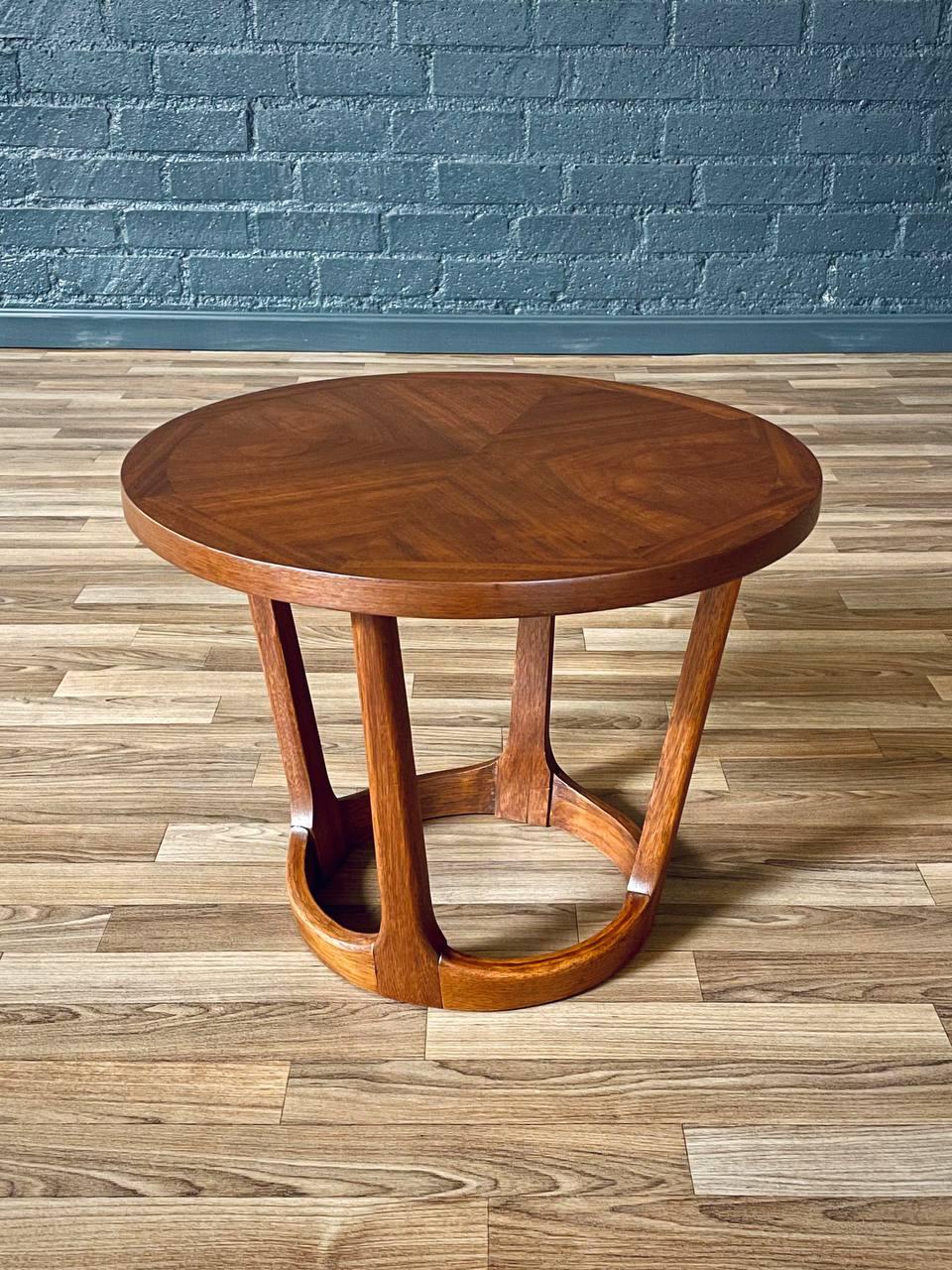 Condition: Expertly Refinished 

This expertly refinished “Rhythm” side table by Lane showcases the refined simplicity and sculptural elegance of Mid-Century Modern design. Crafted in the 1960s from richly grained walnut, the table features a