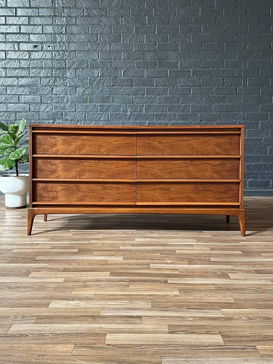 Designed in the 1950s, this expertly refinished Mid-Century Modern “Rhythm” dresser by Lane is a testament to the era’s shift toward sleek, functional, and high-quality craftsmanship. Lane Furniture, founded in 1912 in Altavista, Virginia, became a