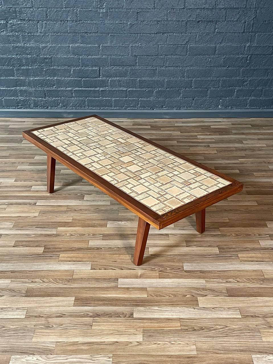 Fabriquée dans les années 1970, cette table basse à plateau en tuiles de style Mid-Century Modern est un magnifique mélange de matériaux organiques et de design fonctionnel. Doté d'un cadre en pin massif teinté en noyer, il met en valeur les riches