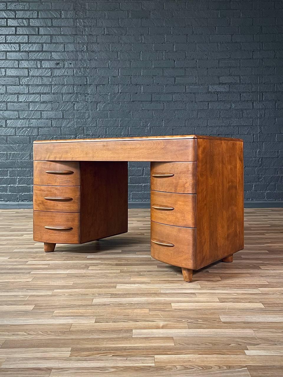 Designer: Heywood Wakefield 
Manufacturer: Heywood Wakefield
Materials: Walnut-Stained Birch Wood

This iconic 1950s Heywood-Wakefield desk is crafted from solid birch wood, reflecting the brand’s commitment to quality and innovation in American