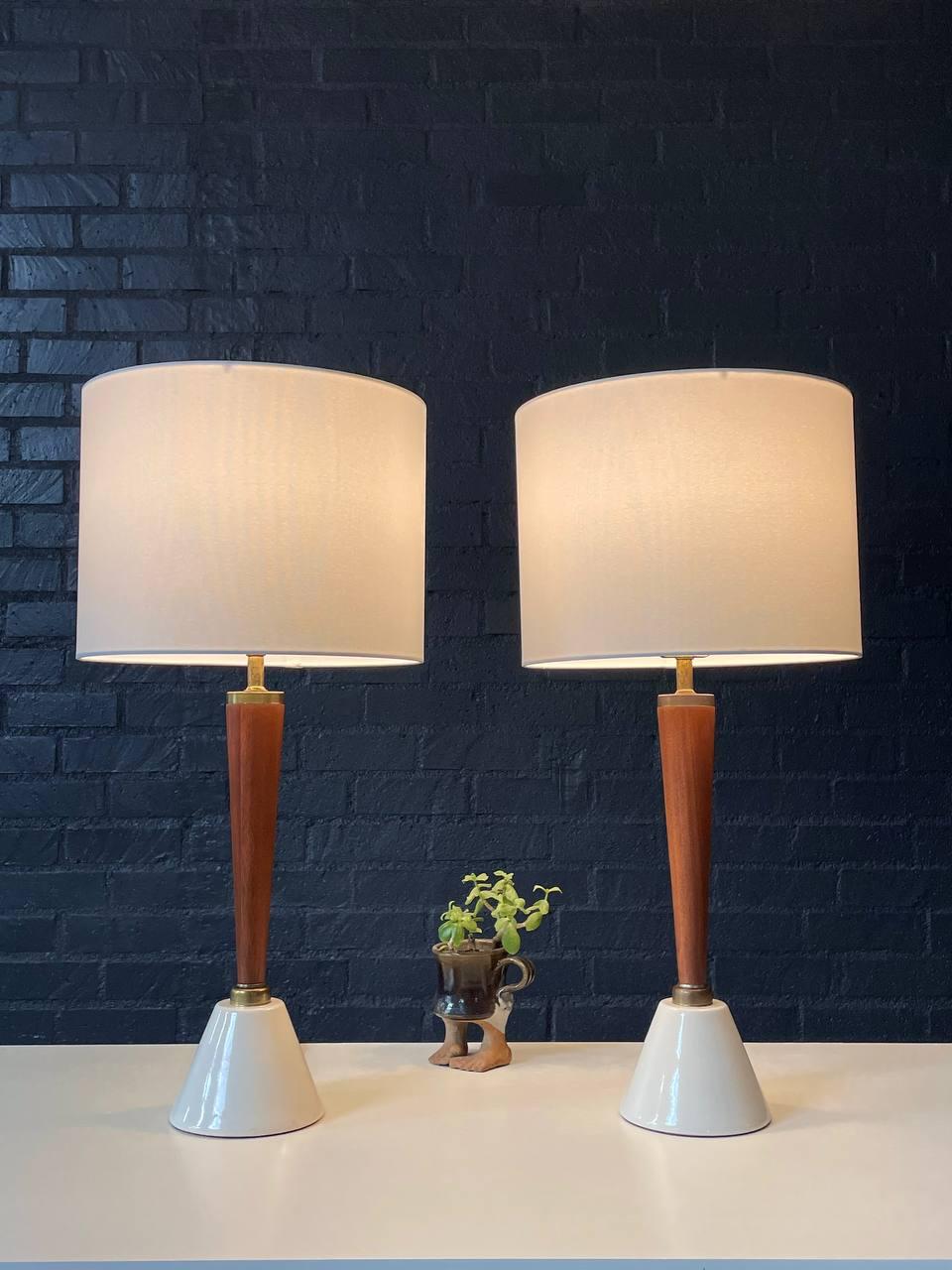 Condition:
Newly Rewired, Newly Refinished, New Linen Shades 

Materials: Cream Glazed Ceramic Base, Walnut, Brass Accents

Dimensions: 
27”H x 5.75”W x 5.75”D
Shade:
10