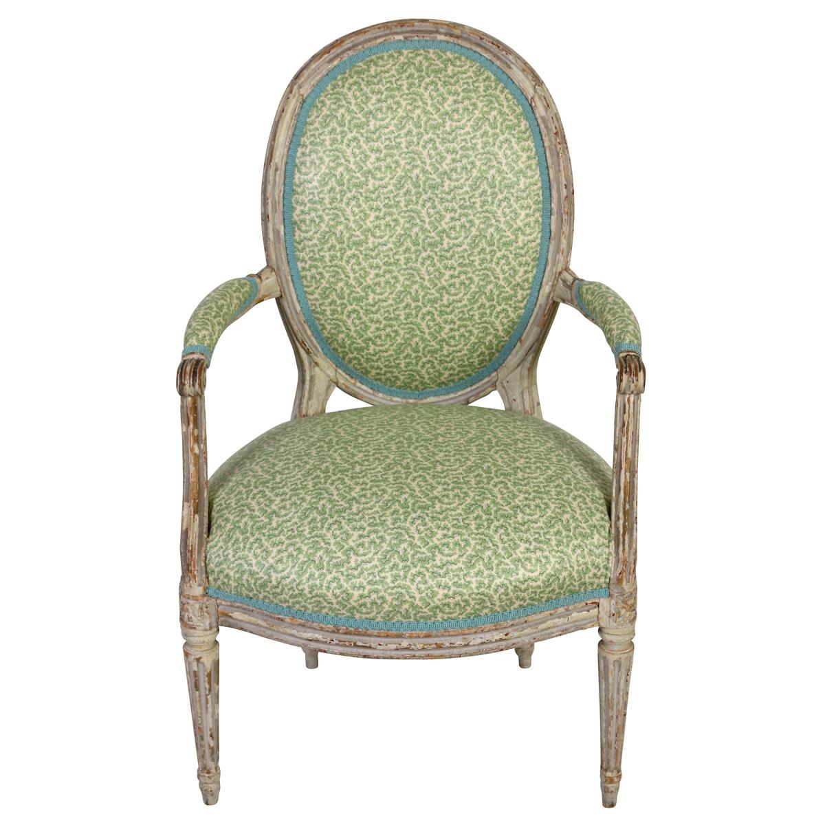 Dieser raffinierte Sessel im Louis-XVI-Stil zeigt mit seinem fein geschnitzten und bemalten Holzrahmen die Eleganz des französischen Designs des 18. Jahrhunderts. Die ovale Rückenlehne und die kannelierten Beine bieten eine klassische Silhouette,