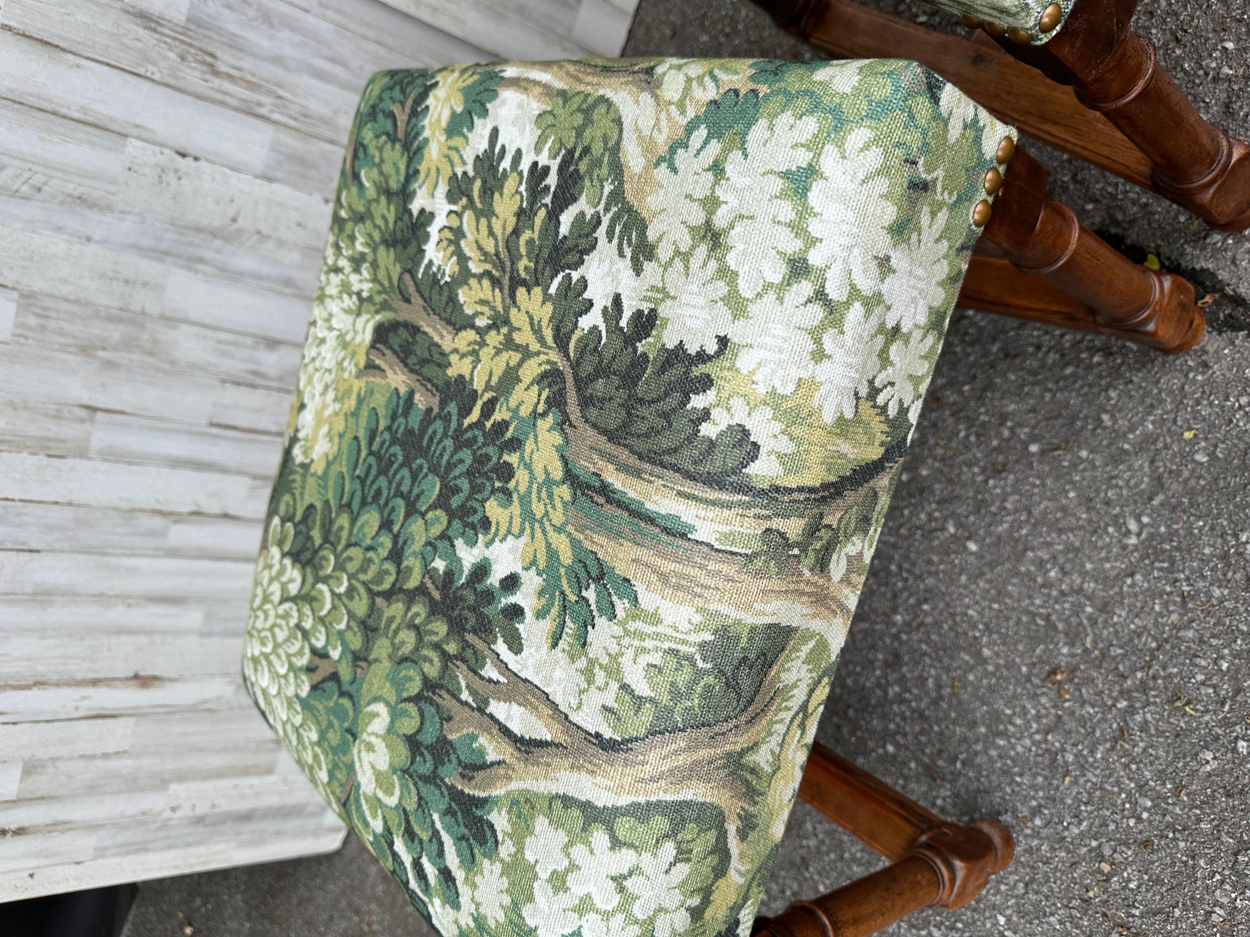 This is a beautiful pair of newly upholstered benches. The fabric is a stunning Multi color green forest scene . The base is solid, hand carved wood, rich brown color that pairs wonderfully with the green fabric and brass nail heads. These would