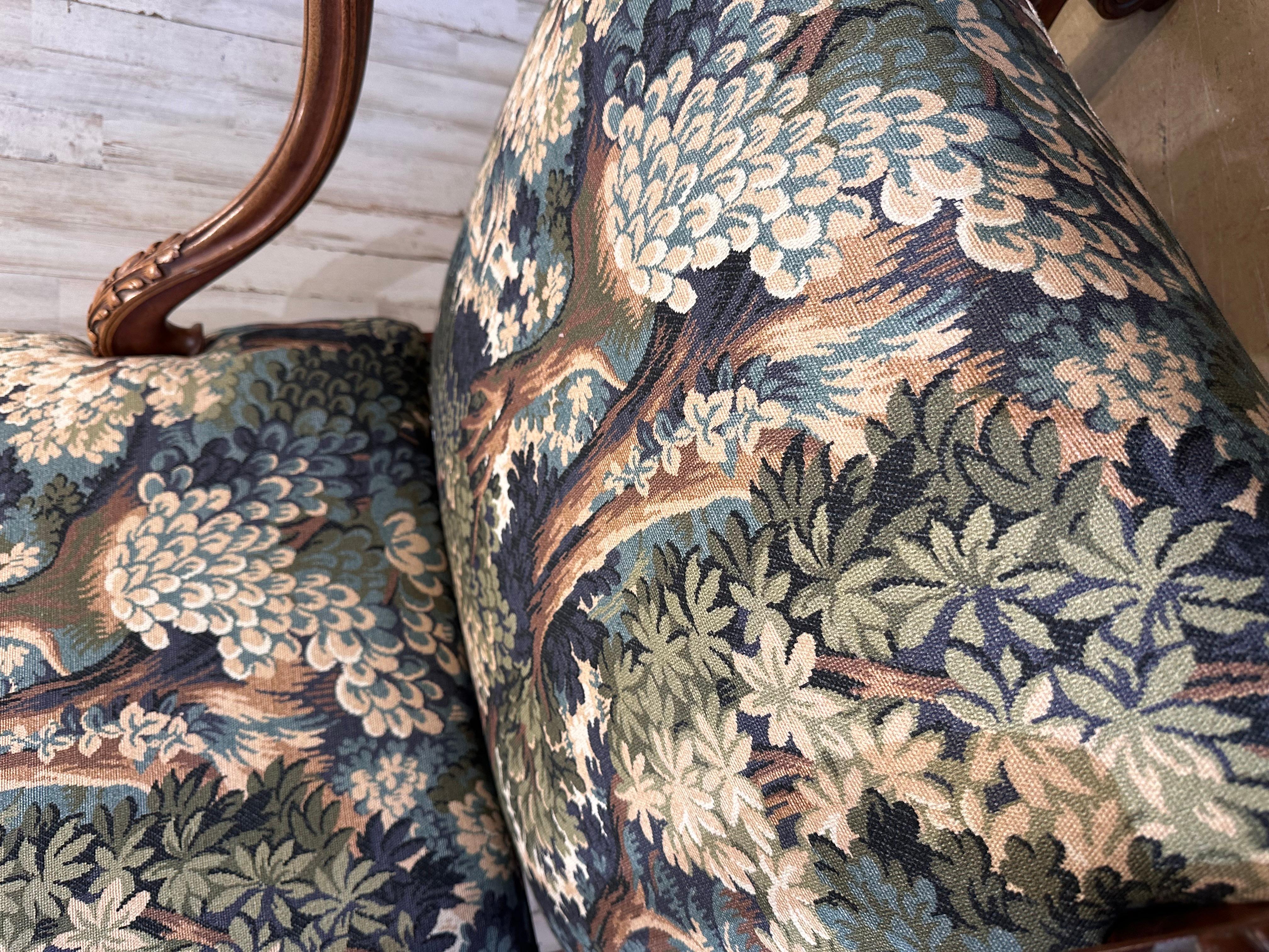 This is a beautiful antique French chair frame that has recently been reupholstered! The new fabric is a gorgeous forest print with deep blue, green, and brown tones mixing with lighter cream and sage hues to create a colorful pattern of leaves and