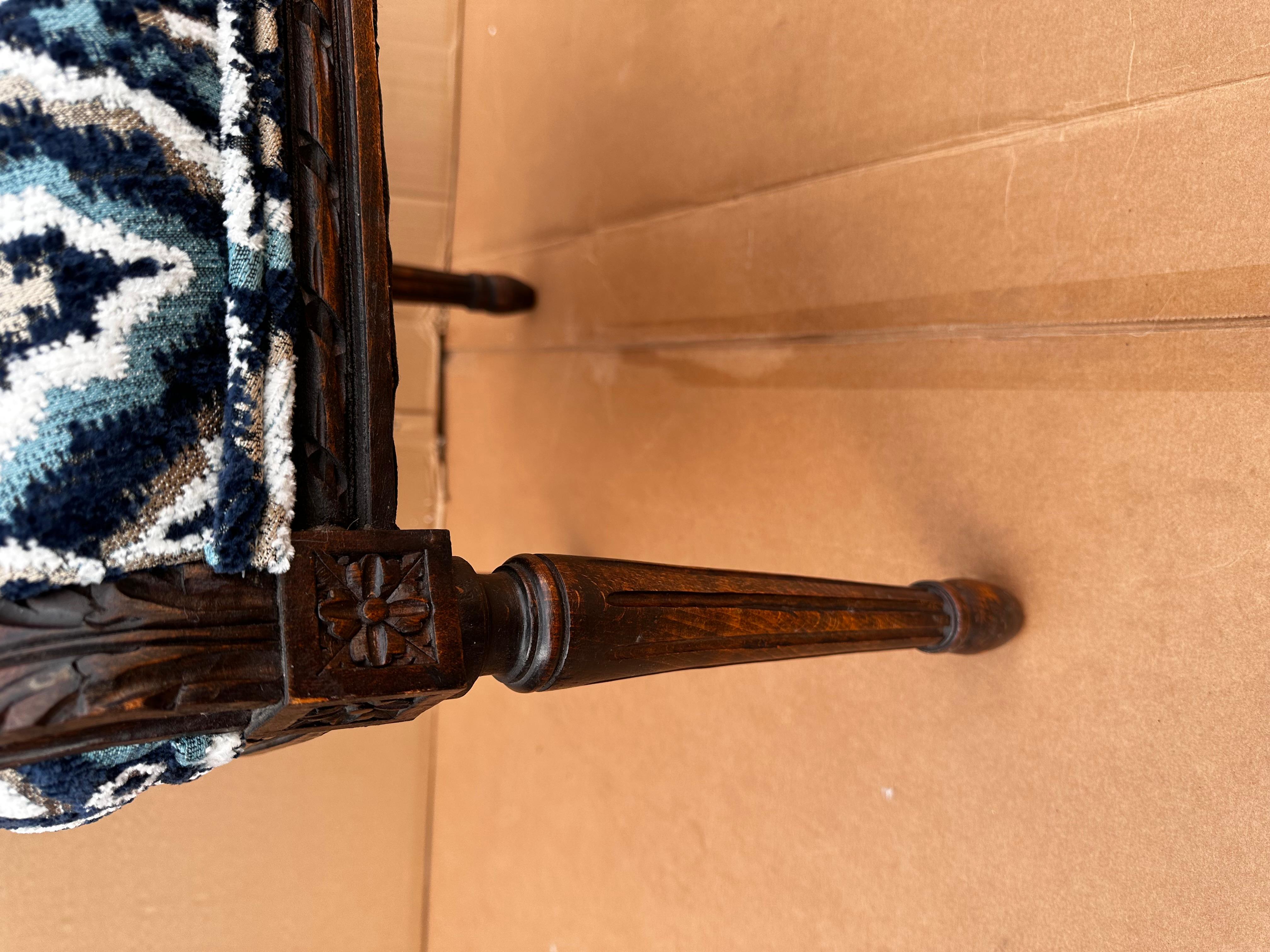 Dieser französische Stuhl ist absolut umwerfend! Der antike Rahmen ist aus dunkelbraunem Holz mit handgeschnitzten Details an den Kanten und oben. Er wurde neu gepolstert und mit einem wunderschönen tiefblauen und weißen Stoff mit oliv- und