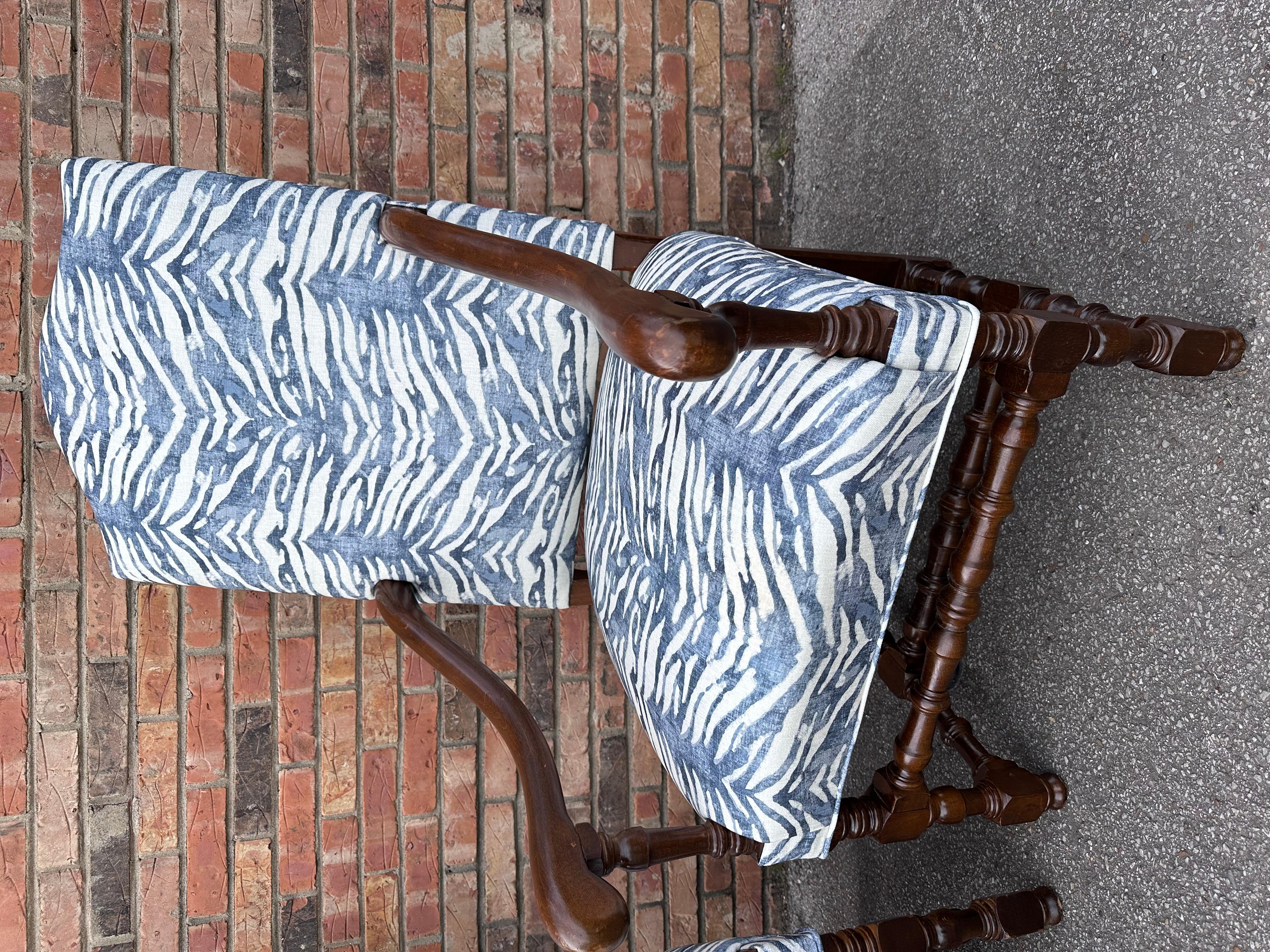 Old meets new, in this beautiful pairing of antique frames with this new fabric. The dark aged wood has beautiful turning detail on the legs, and the arms are smoothly curved with excellent patina. The fabric is a modern striped style blue and white