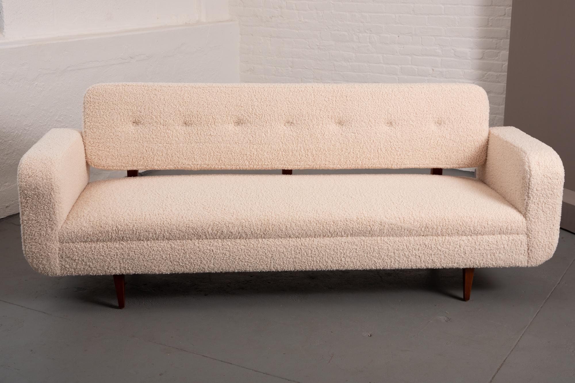 Mid-Century Modern sofa newly upholstered in natural/ivory boucle. Button tufting to the seat back. Sculptural wood upright detail to rear of sofa. Rounded arms and seat back.
Measures: Seat depth - 19