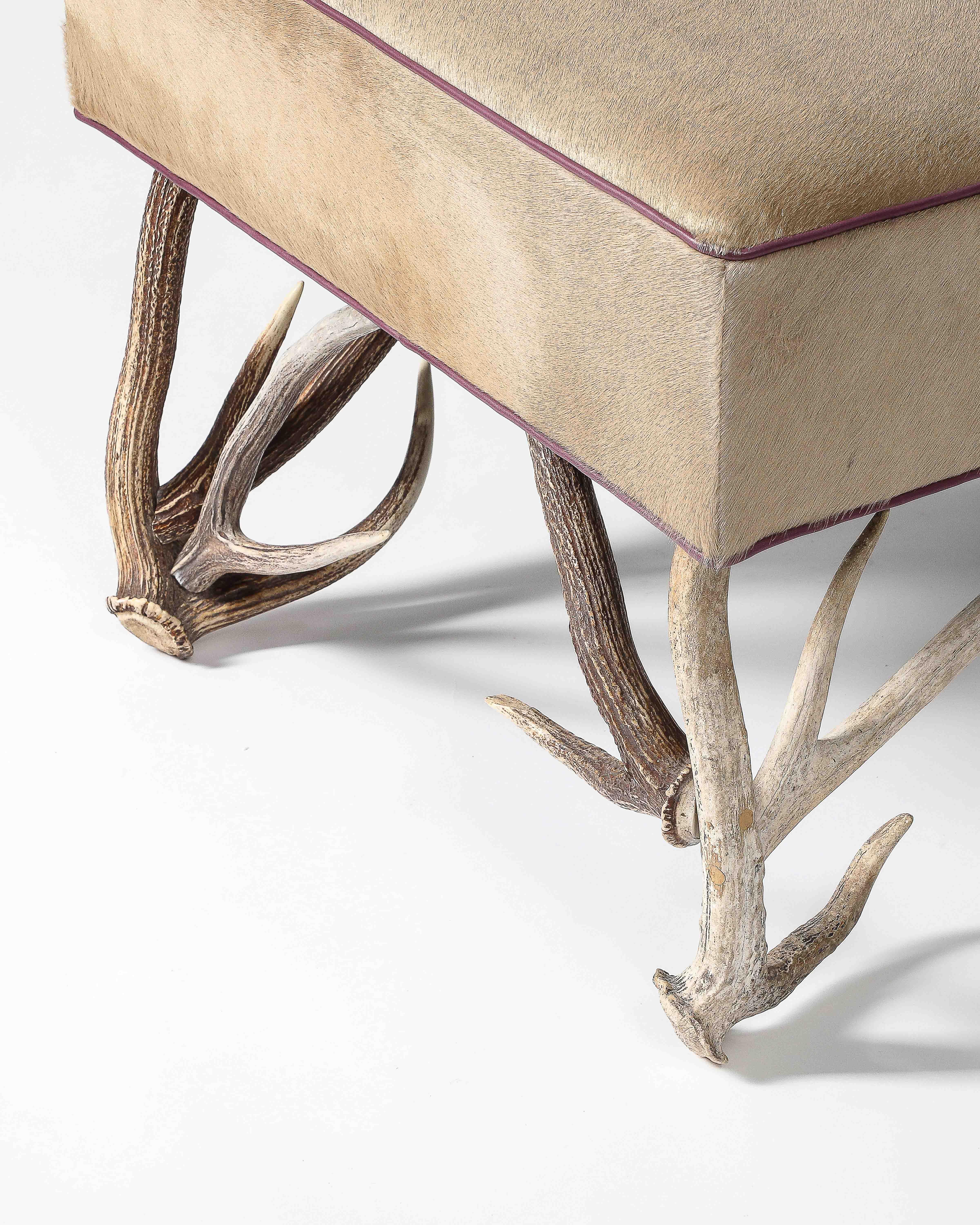 Priced individually; two available.

Unique stools with sand-colored hair on hide and deep purple leather piping.  Fitted with perfectly sized antlers. 