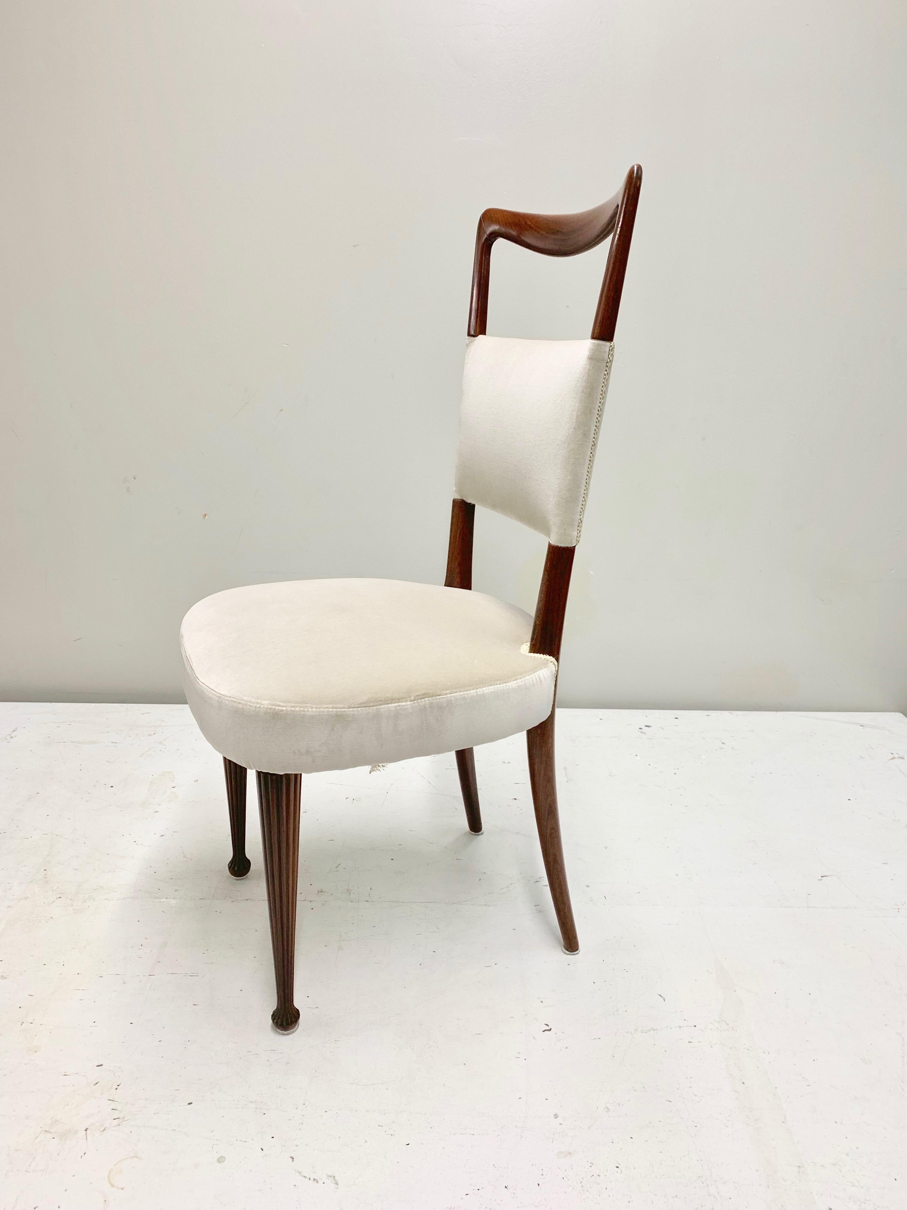 Set of four Osvaldo Borsani dining chairs with a solid and heavy rosewood structure, newly reupholstered with a light gray 100% cotton velvet from Italy. The seat cushion is comfortable and wide, the front legs are carved in the wood and adds up an