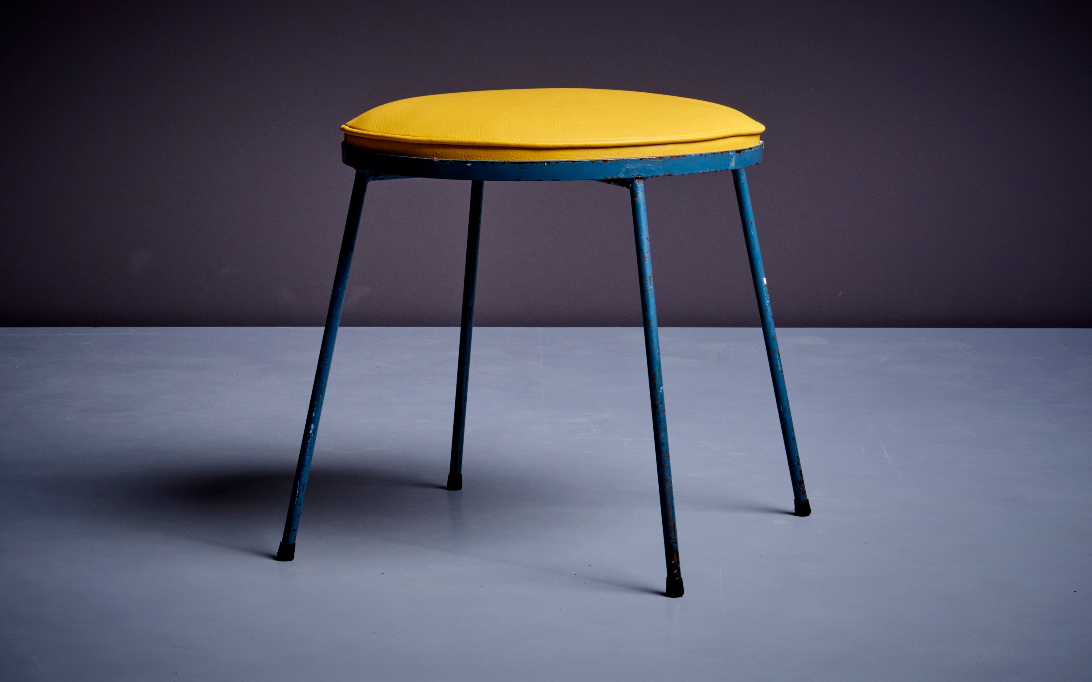 Authentic and rare signed Frederic Weinberg stool, circa 1960. Newly upholstered in yellow leatherette upon wrought iron frames, with label. Ideal for use as stool, footstool or ottoman. Diameter of the seat is 40 cm.